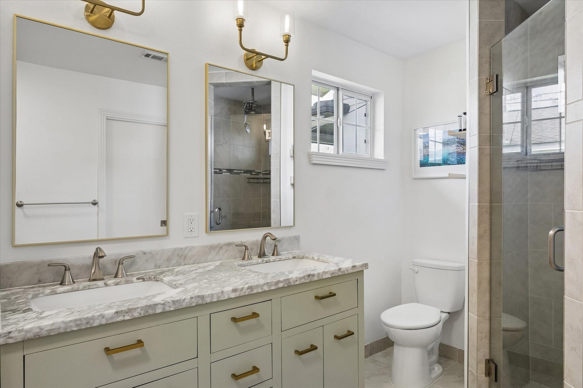1232 Chantilly Lane, Houston, TX 77018 Updated primary bathroom features a double vanity with quartzite countertops, modern brass accents, and a glass enclosed walk in shower.