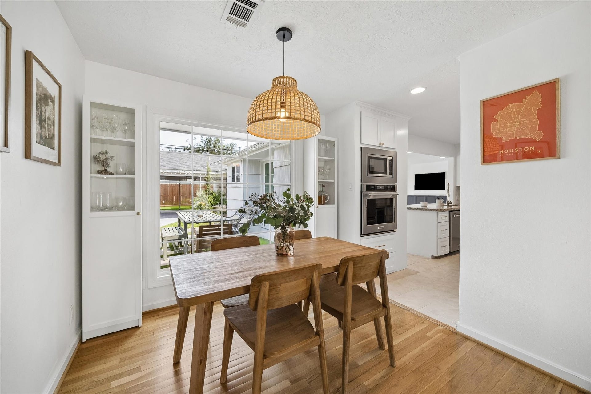 1232 Chantilly Lane, Houston, TX 77018 Dining room with built in display cabinetry, statement pendant lighting, and a large picture window overlooking the backyard, with easy access to the updated kitchen.