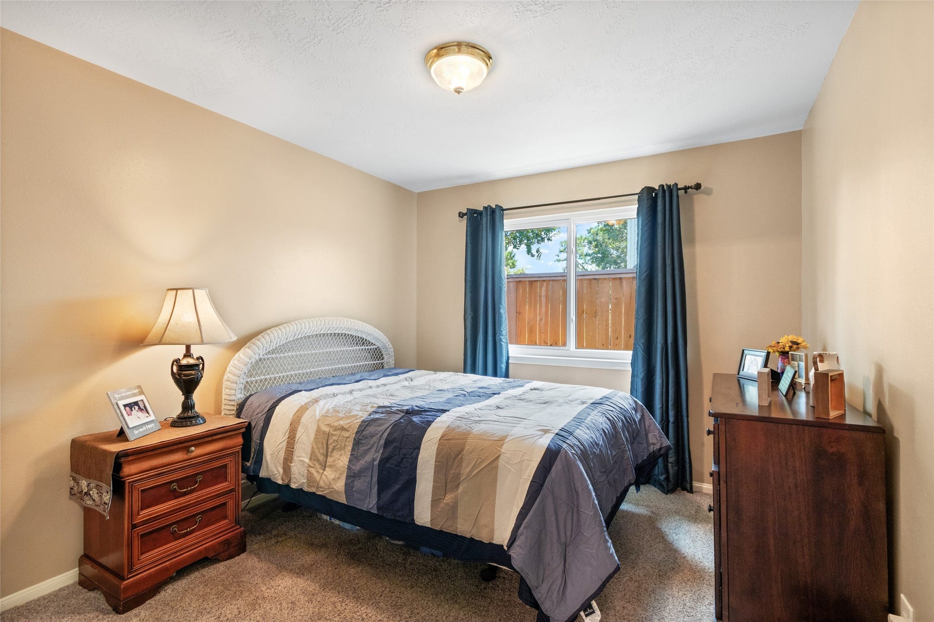 3001 Meadow Bay Drive, Dickinson, TX 77539 Cozy bedroom with neutral walls, a large window for natural light, and space for a double bed, nightstand, and dresser.