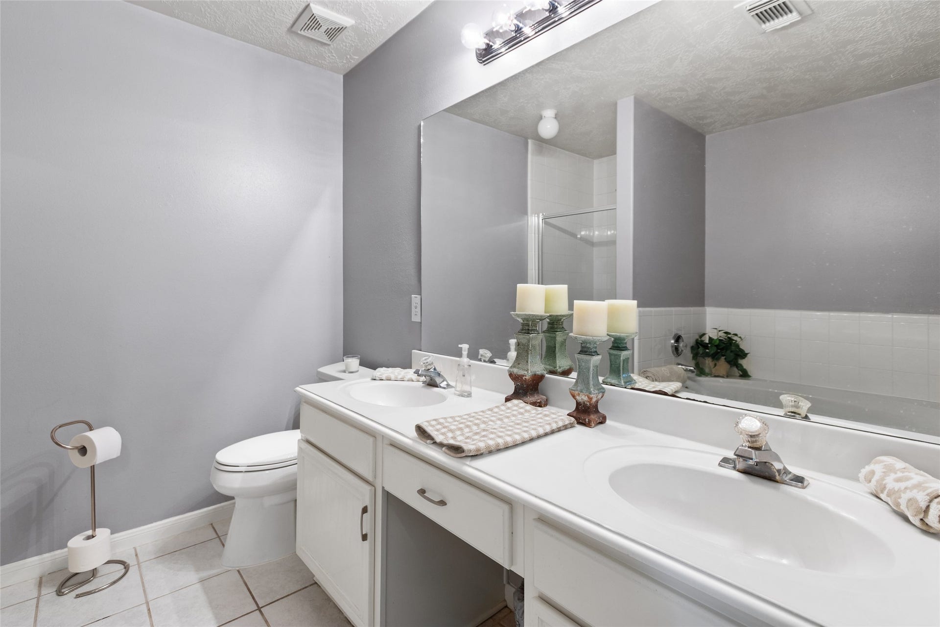3001 Meadow Bay Drive, Dickinson, TX 77539 Elegant bathroom with dual sinks, modern fixtures, and ample counter space, complemented by soft gray walls and bright lighting for a serene atmosphere.