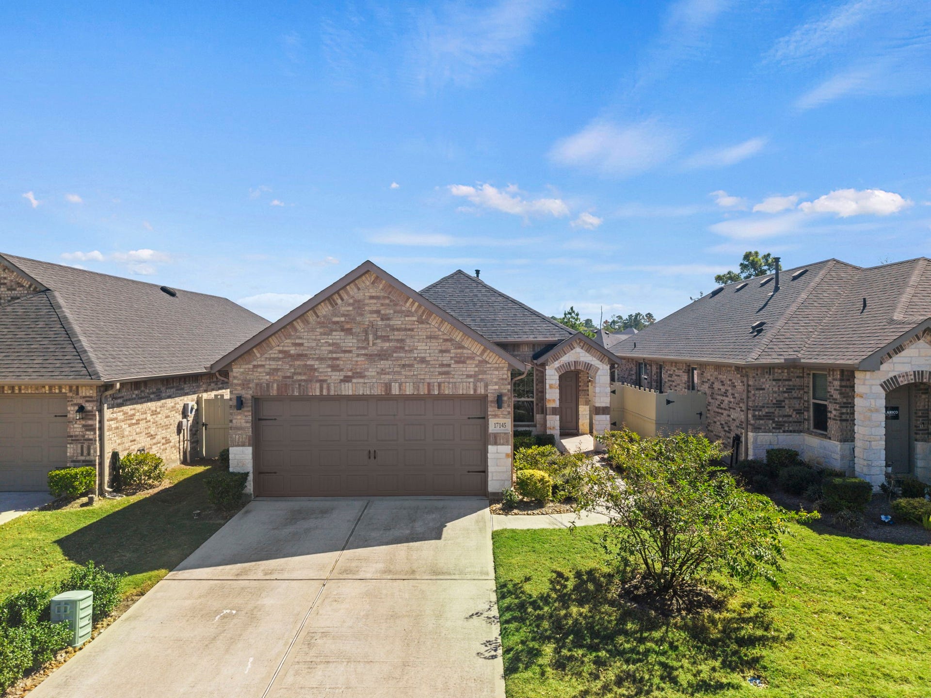 Beautiful single-story brick home with charming curb appeal, a welcoming covered entry, and a spacious driveway leading to a two-car garage.
