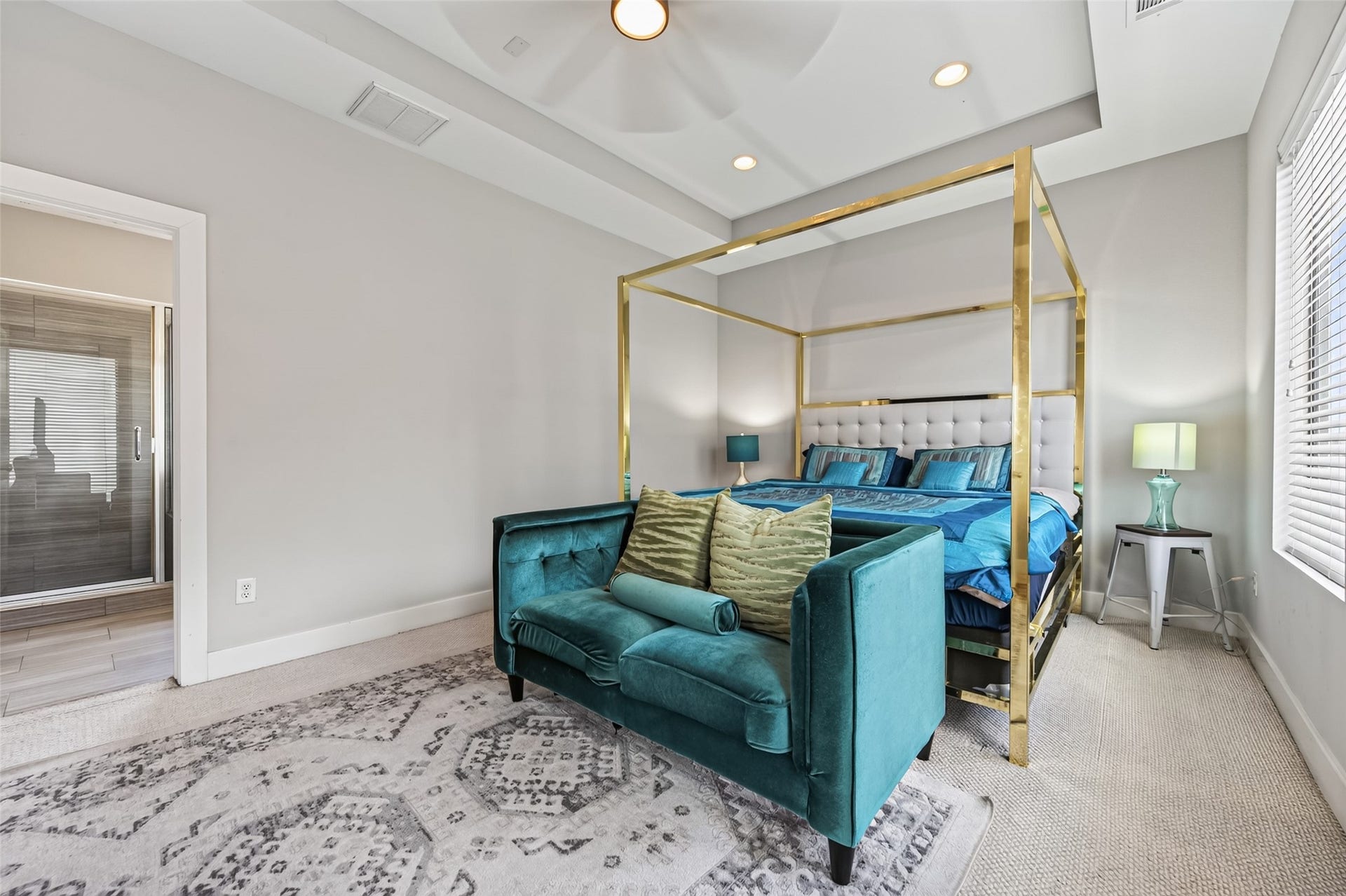 2805 Blodgett Street, #C, Houston, TX 77004 Spacious bedroom featuring a luxurious canopy bed, modern ceiling fan, and ample natural light from large windows, complemented by a cozy seating area and stylish decor.