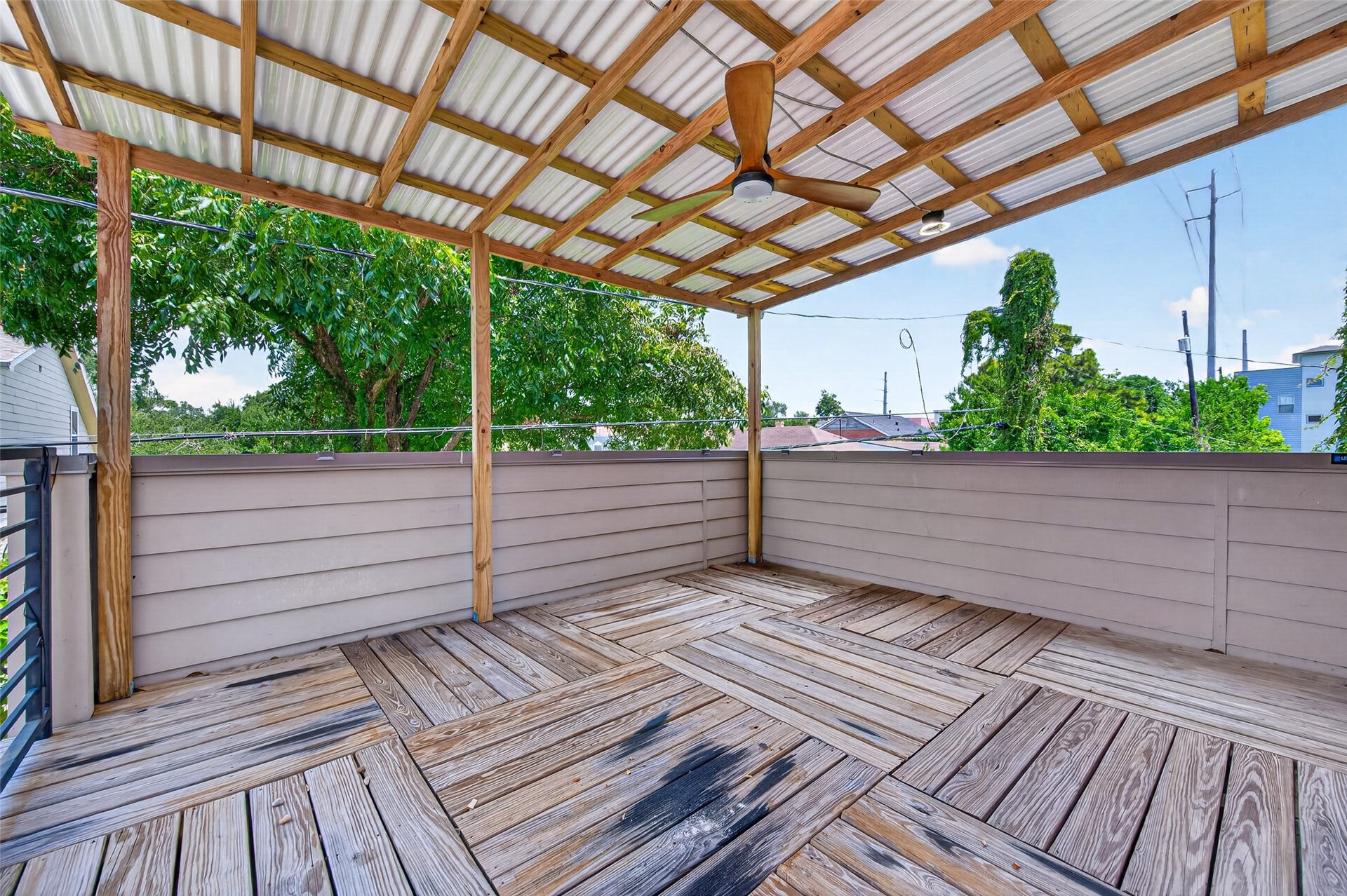 2805 Blodgett Street, #C, Houston, TX 77004 Spacious covered deck with a stylish wood pattern, perfect for outdoor relaxation and entertaining, featuring a ceiling fan for comfort.