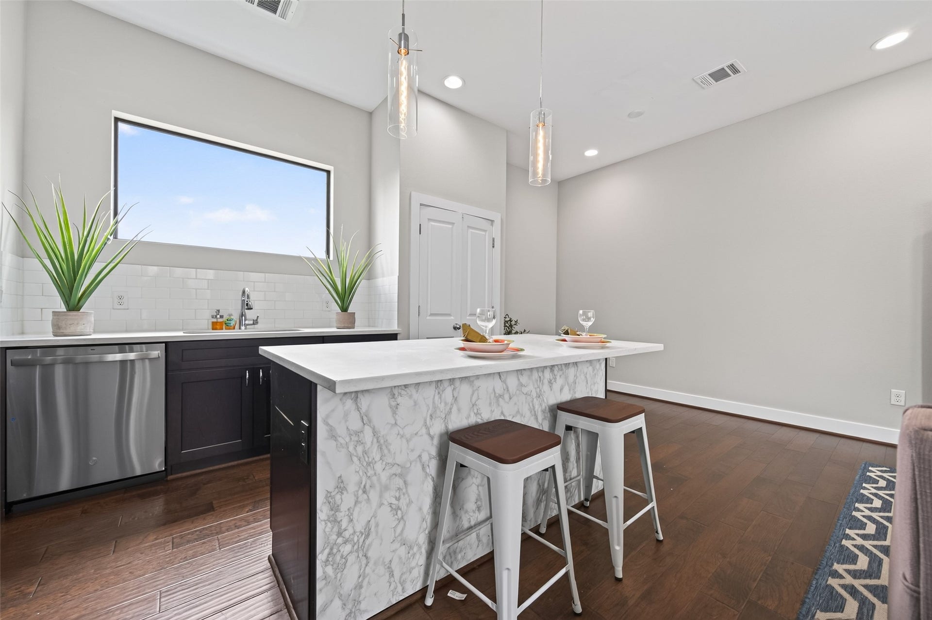 2805 Blodgett Street, #C, Houston, TX 77004 Modern open-concept living area featuring sleek hardwood floors, a central island with dark cabinetry, and ample natural light from large windows.