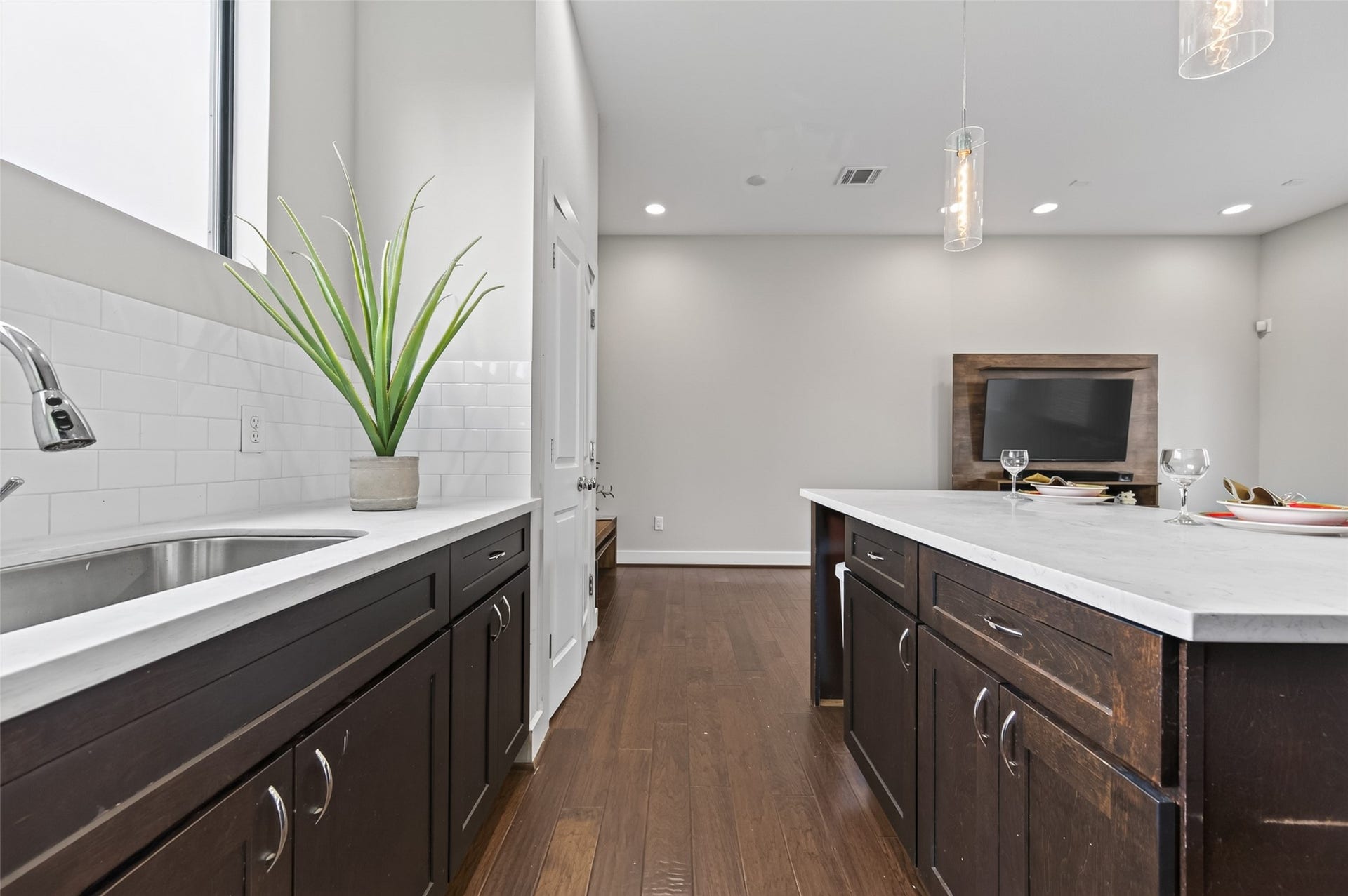 2805 Blodgett Street, #C, Houston, TX 77004 Modern kitchen with stainless steel appliances, dark wood cabinetry, and sleek white countertops.