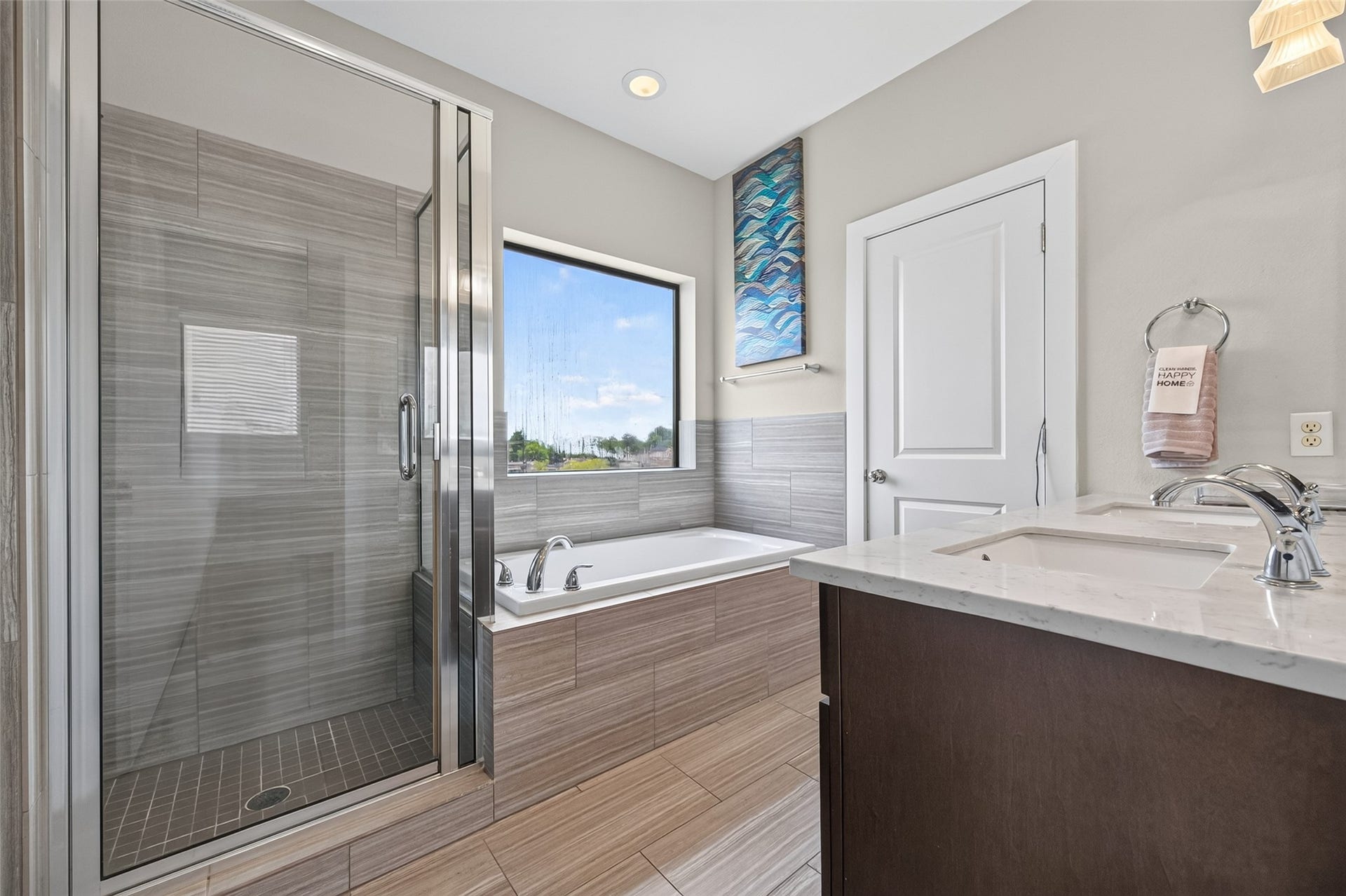 2805 Blodgett Street, #C, Houston, TX 77004 Modern bathroom featuring a spacious glass-enclosed shower, sleek soaking tub beneath a large window, and a stylish vanity with dual sinks, offering both elegance and functionality.