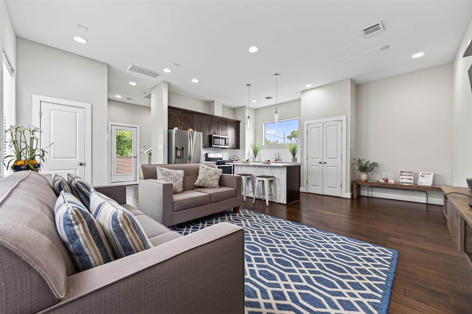 2805 Blodgett Street, #C, Houston, TX 77004 Bright and modern living space with an open-concept design, featuring sleek hardwood floors, a stylish kitchen with a marble countertop island, and a cozy seating area perfect for relaxation.