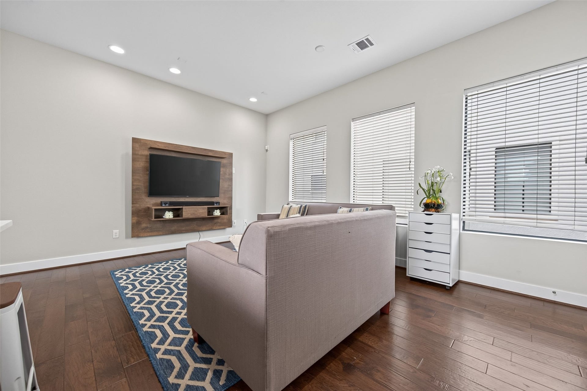 2805 Blodgett Street, #C, Houston, TX 77004 Bright and inviting open-concept living area featuring stylish sofas, a chic geometric rug, and a sleek, modern kitchen with stainless steel appliances.