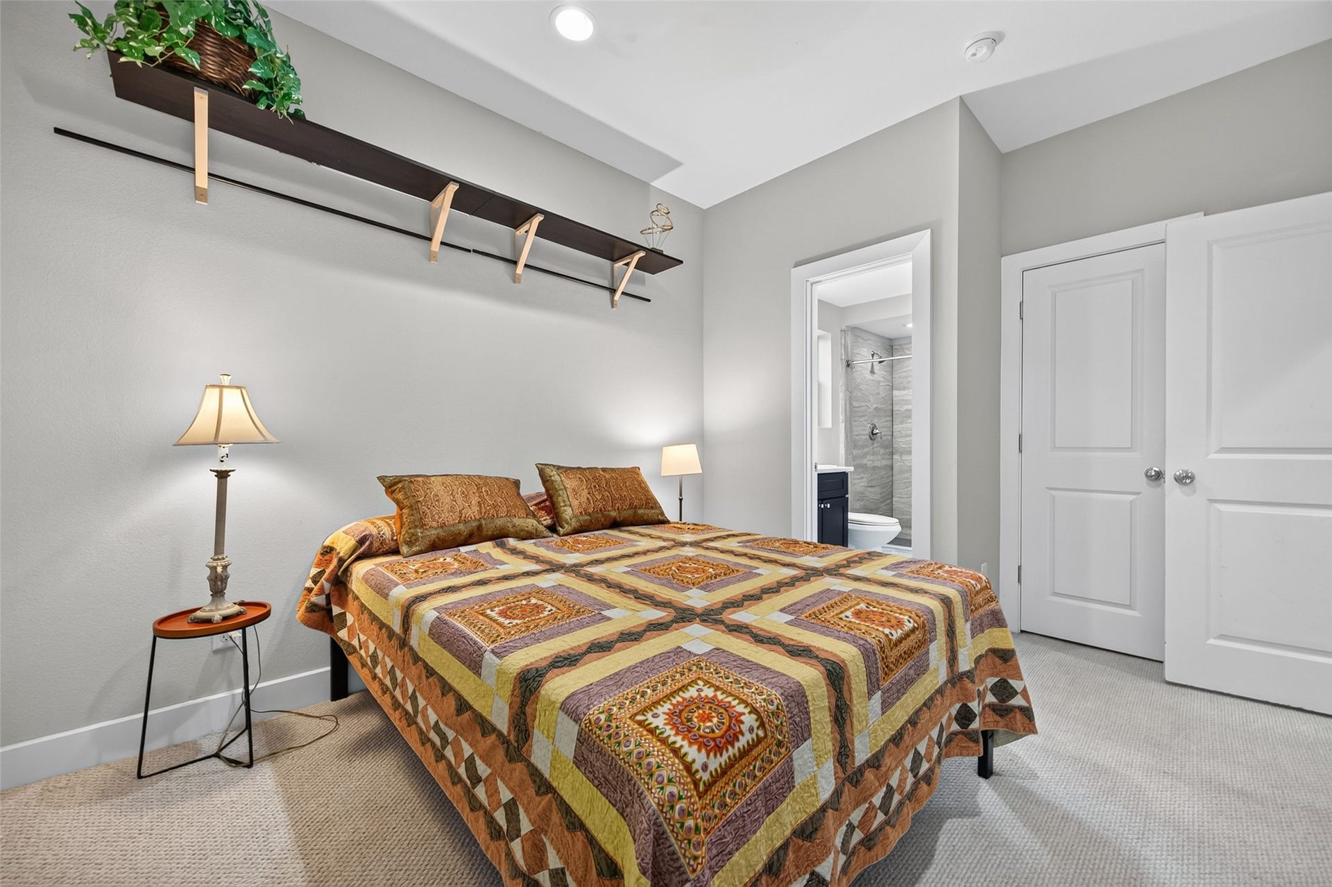 2805 Blodgett Street, #C, Houston, TX 77004 Cozy bedroom with a warm color palette, featuring a comfortable bed, soft lighting, and a window offering natural light and greenery views.