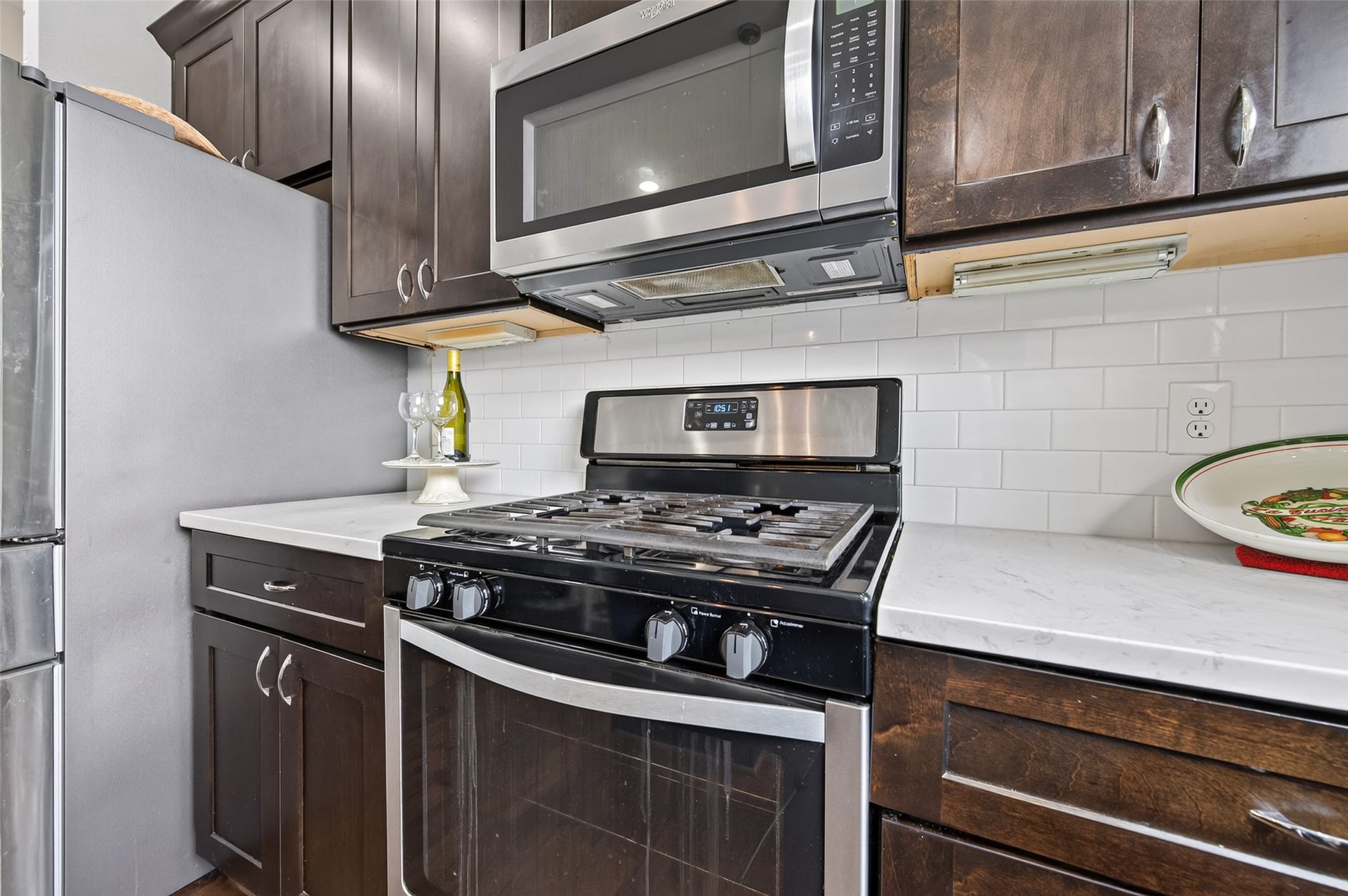 2805 Blodgett Street, #C, Houston, TX 77004 Modern kitchen with sleek stainless steel appliances, dark wood cabinetry, and a spacious island, seamlessly flowing into a cozy living area with ample natural light.