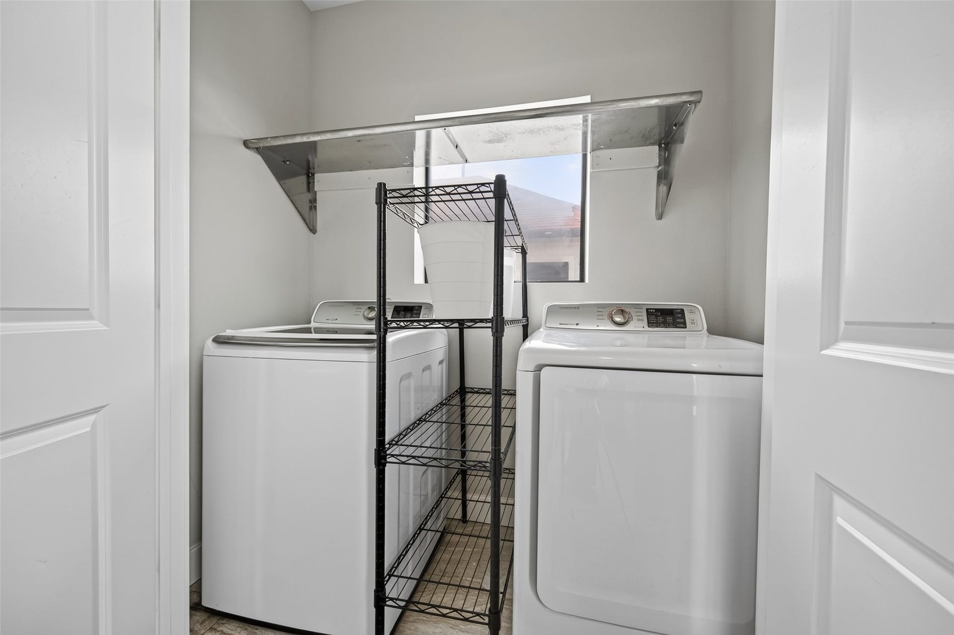 2805 Blodgett Street, #C, Houston, TX 77004 Convenient laundry room with modern washer and dryer, featuring ample shelving for storage and organization.