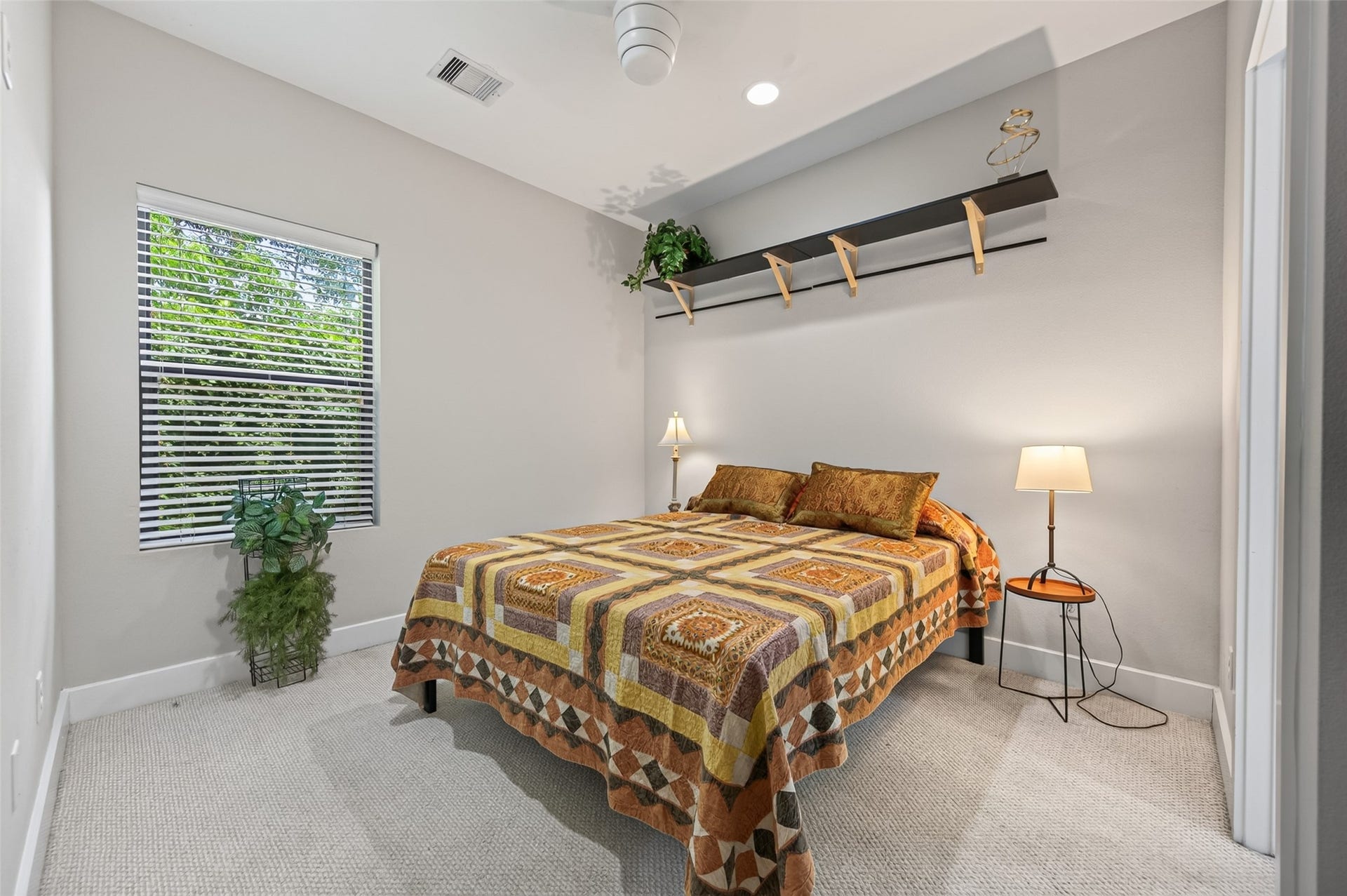 2805 Blodgett Street, #C, Houston, TX 77004 Cozy bedroom with a warm quilted bedspread, soft lighting, and en-suite bathroom access.