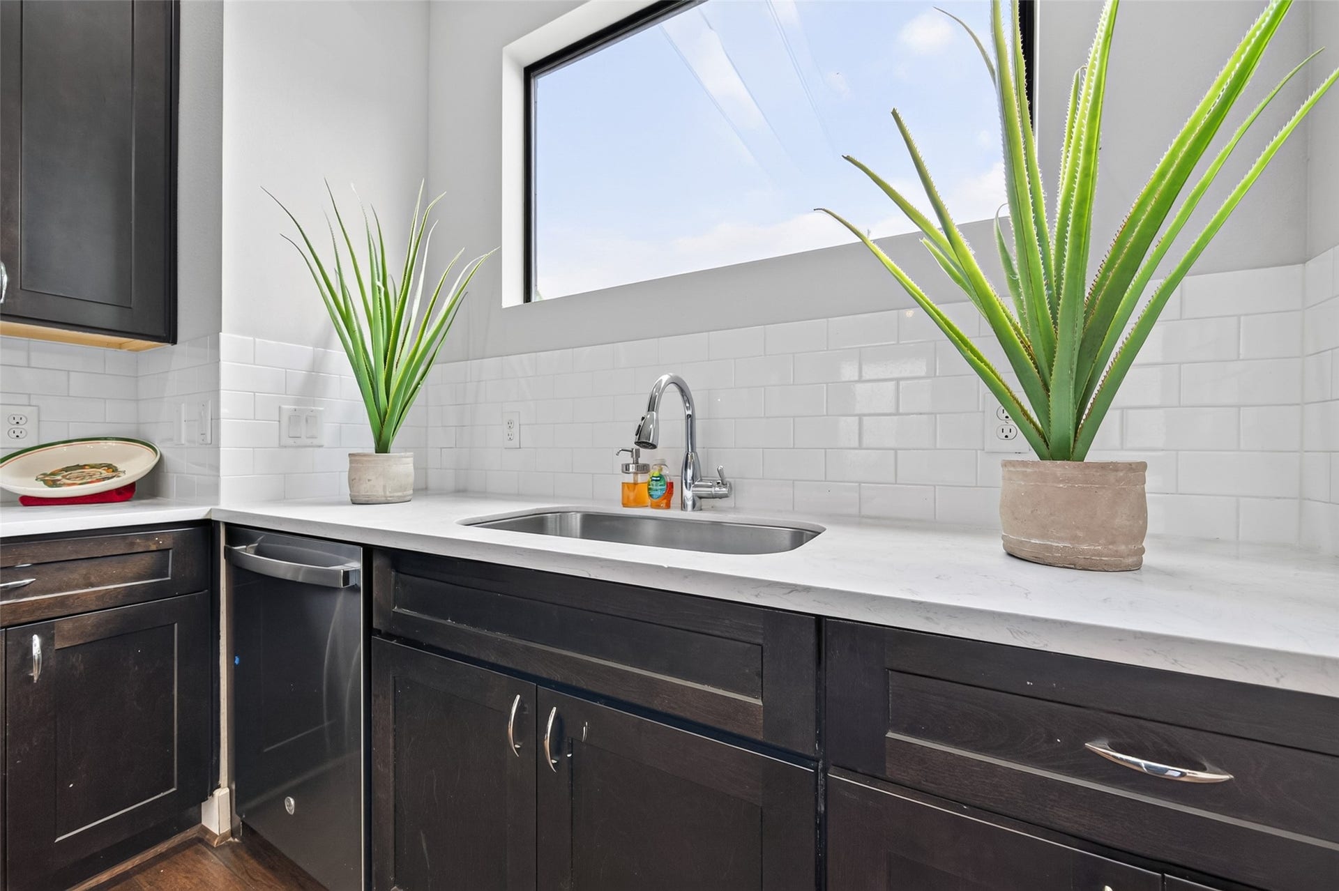 2805 Blodgett Street, #C, Houston, TX 77004 Sleek kitchen featuring rich dark wood cabinetry, stainless steel appliances, and elegant marble countertops, offering ample workspace and a modern aesthetic.