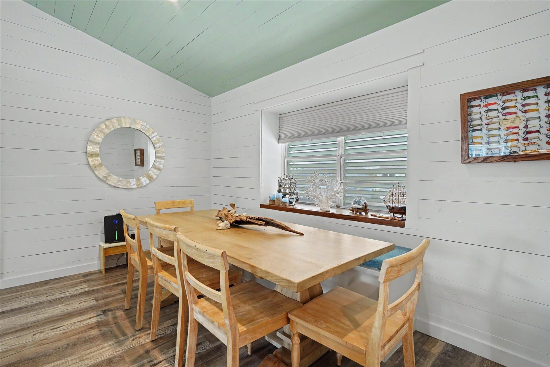 This charming dining area features a custom built-in bench with hidden storage, creating the perfect spot for family meals, entertaining, or enjoying your morning coffee. Thoughtful design meets everyday functionality in this beautifully remodeled coastal home