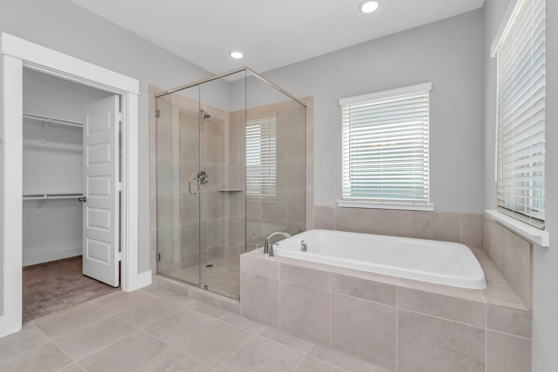 Spa-Like Bath with Spacious Walk-In Shower, Soaking Tub, & Double Sinks with Luxurious Quartz Countertops.