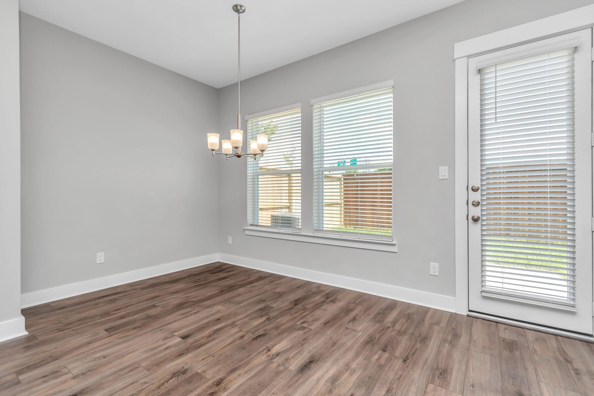 Light & Bright Dining Area with Luxurious Wood-Like Vinyl Plank Flooring.