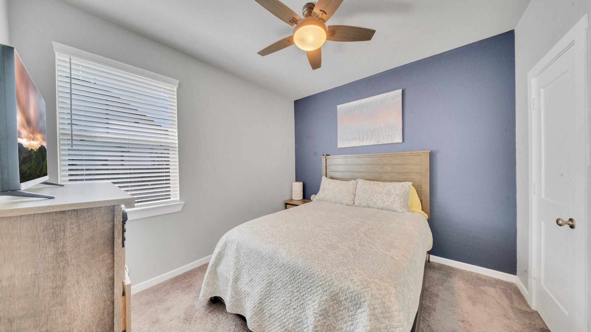 6123 Dovetail Cliff Court, Katy, TX 77493 Comfortable secondary bedroom with natural light and a stylish accent wall.