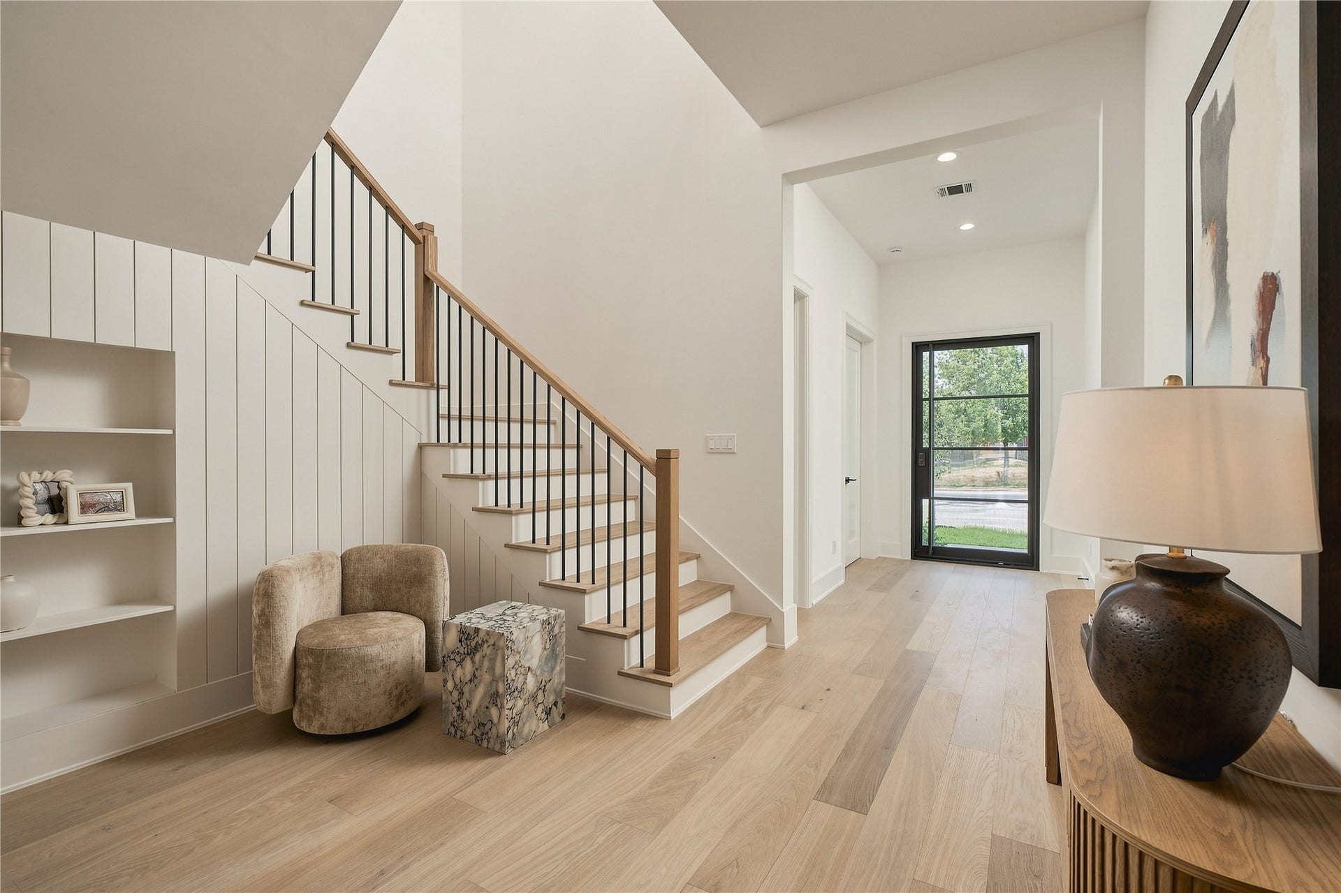 2109 McKean Drive, Houston, TX 77080 An intimate sitting area creates a natural pause between spaces, while the open staircase adds architectural interest and a sense of connection throughout the home.