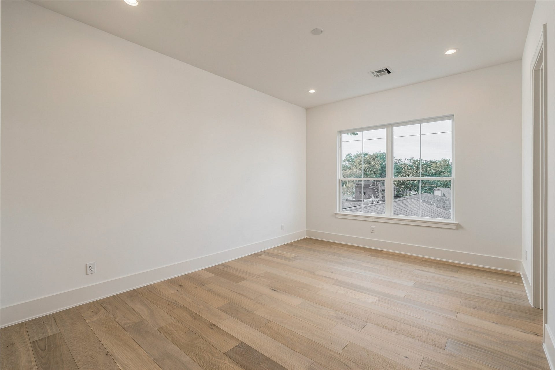 2109 McKean Drive, Houston, TX 77080 This secondary bedroom offers a bright, versatile canvas, with wide-plank oak flooring and a large window overlooking the backyard.