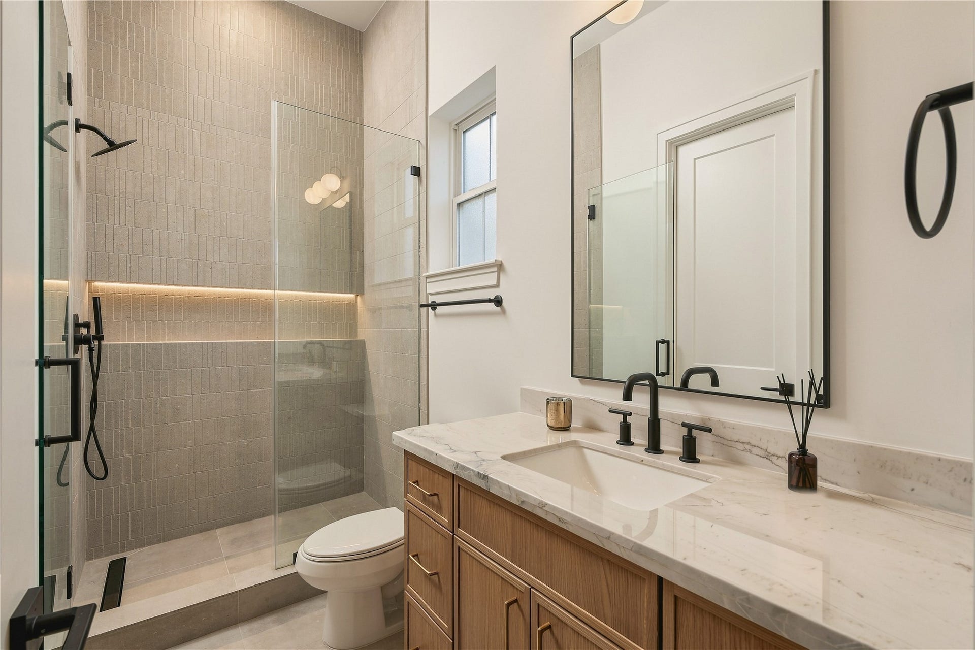 2109 McKean Drive, Houston, TX 77080 The study is complemented by its own full bath, finished with Mount Blanc Quartzite, designer tile extending to the ceiling, and a frameless glass showerallowing the space to easily function as a private