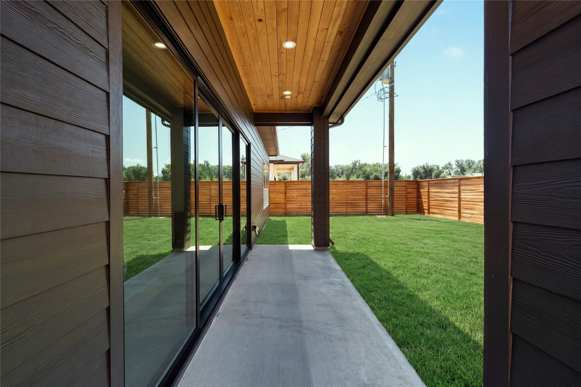 2109 McKean Drive, Houston, TX 77080 The covered patio creates a true outdoor extension of the home, framed by warm tongue-and-groove wood soffits and opening to an expansive 30' x 60' backyard with room to create a future pool or outdoor retreat.