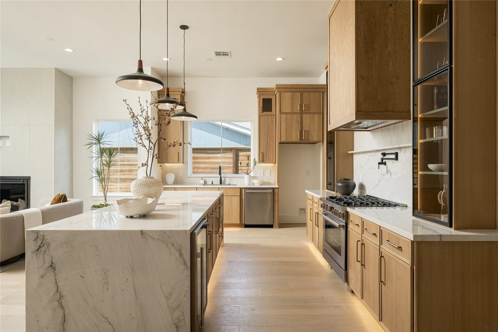 2109 McKean Drive, Houston, TX 77080 Custom Midnight Glass Towers frame the Bosch range, complemented by a white oak vent hood and illuminated cabinetry that gives the kitchen a distinctly tailored, furniture-like quality.
