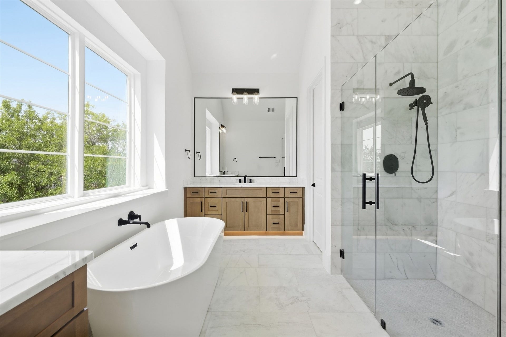 2111 Nantucket Drive, #D, Houston, TX 77057 A freestanding soaking tub anchors the primary bath, creating a peaceful retreat designed for slowing down and relaxing.