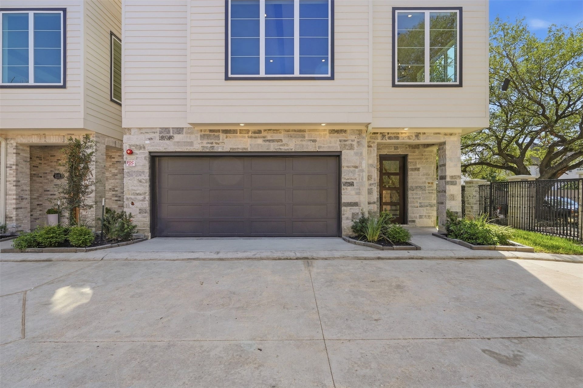 2111 Nantucket Drive, #D, Houston, TX 77057 Welcome to Residence D at Four Oaks at Nantucket, featuring a private two-car garage, stone-accented exterior, covered entry, and modern architectural details.