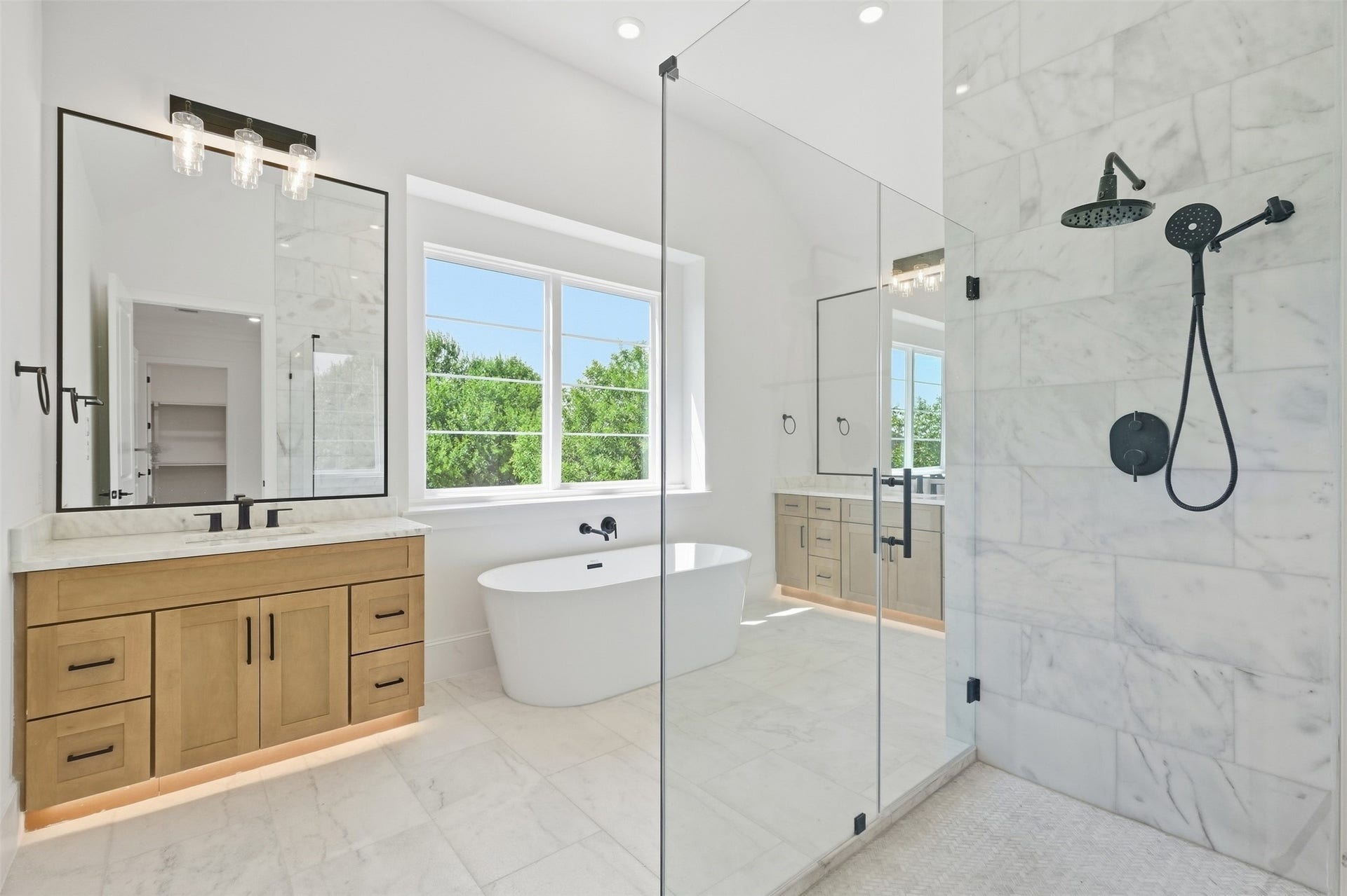 2111 Nantucket Drive, #D, Houston, TX 77057 The spa-inspired primary bath features a freestanding soaking tub, oversized glass-enclosed shower, dual vanities, and beautiful marble finishes.