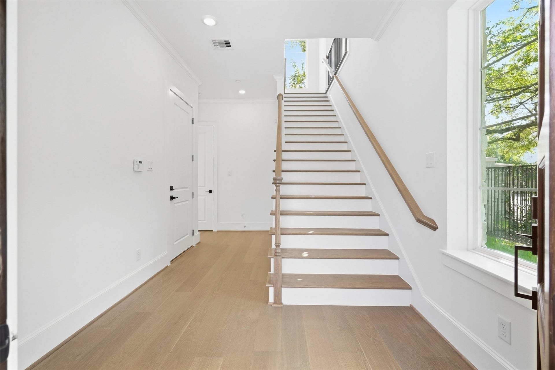 2111 Nantucket Drive, #D, Houston, TX 77057 A welcoming entry introduces Residence D with warm wood-toned flooring, crisp millwork, and a light-filled staircase leading into the home.