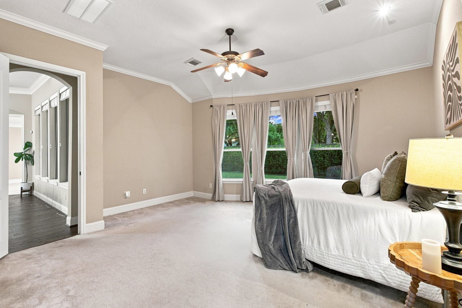 Primary overlooks beautifully manicured hedges and the backyard.