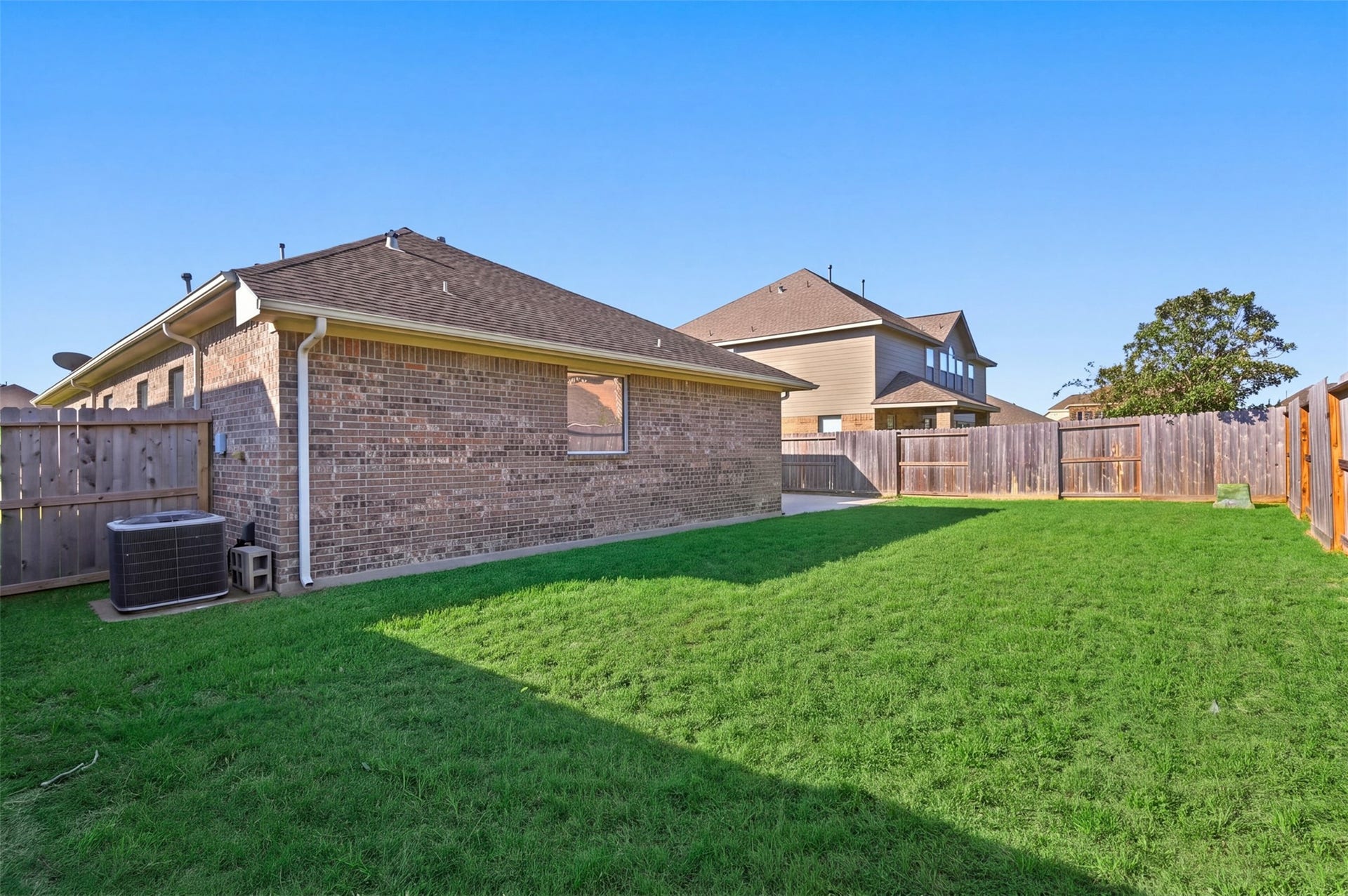 6414 Pinyon Trail Drive, Spring, TX 77389 Spacious backyard with lush green lawn, perfect for outdoor activities and relaxation, surrounded by a sturdy wooden fence for added privacy.