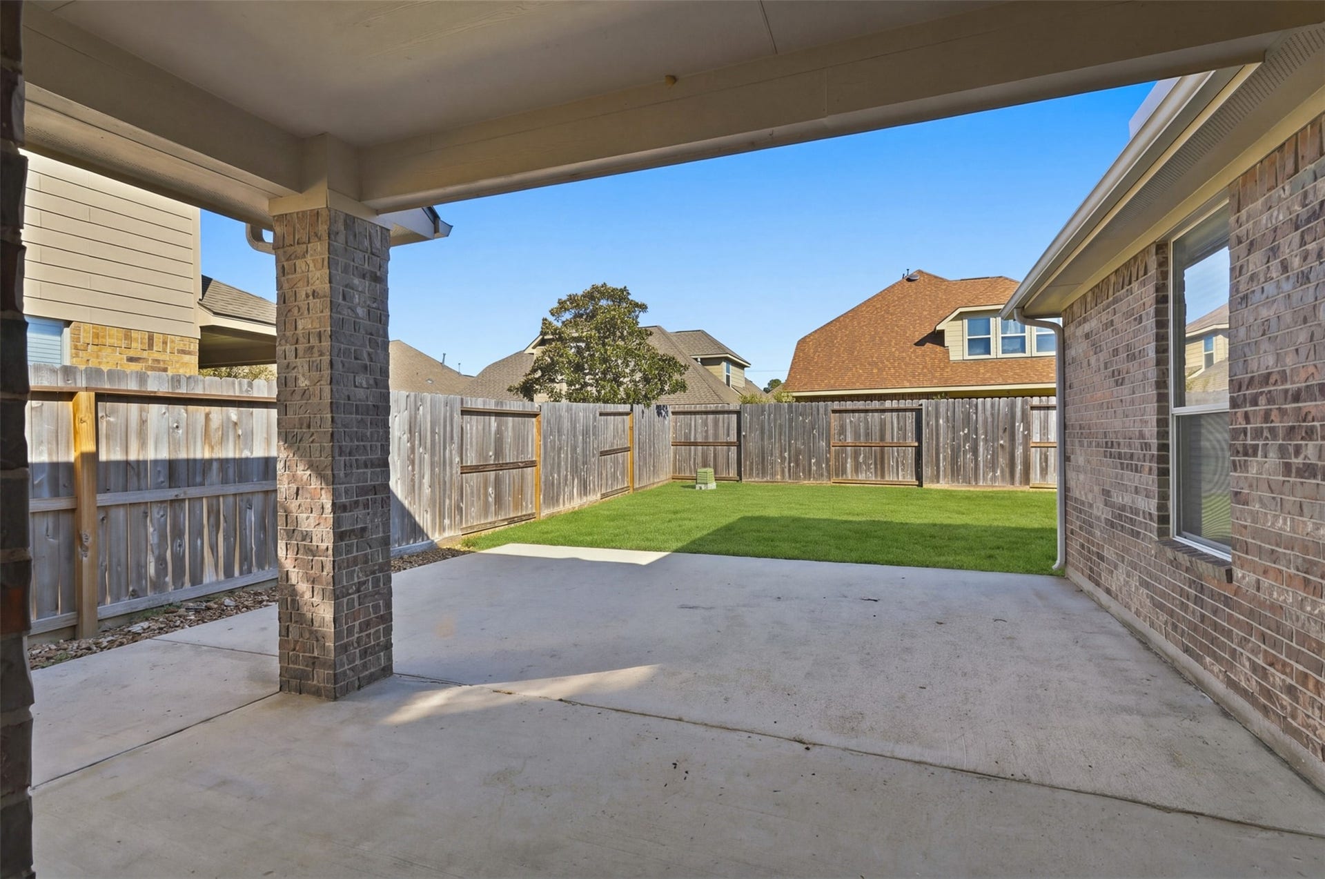 6414 Pinyon Trail Drive, Spring, TX 77389 The covered patio overlooks a private, fenced backyard with lush green lawn, perfect for outdoor relaxation and entertainment.