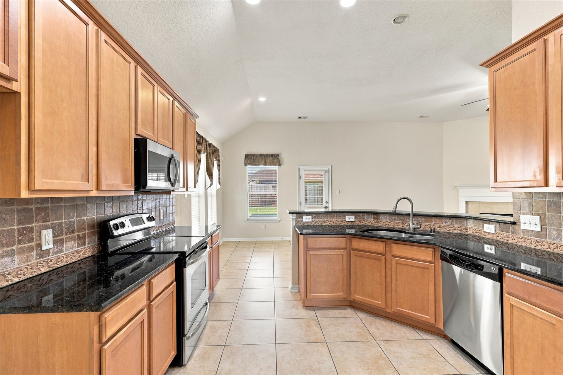 6414 Pinyon Trail Drive, Spring, TX 77389 Spacious kitchen with sleek granite countertops, stainless steel appliances, and rich wood cabinetry, perfect for culinary enthusiasts.