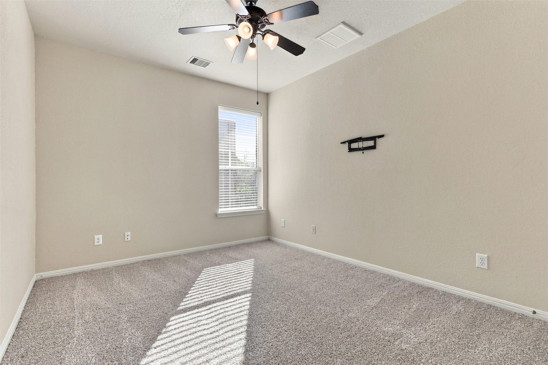6414 Pinyon Trail Drive, Spring, TX 77389 Bright and inviting bedroom featuring plush carpeting, a modern ceiling fan, and ample natural light streaming through a large window.