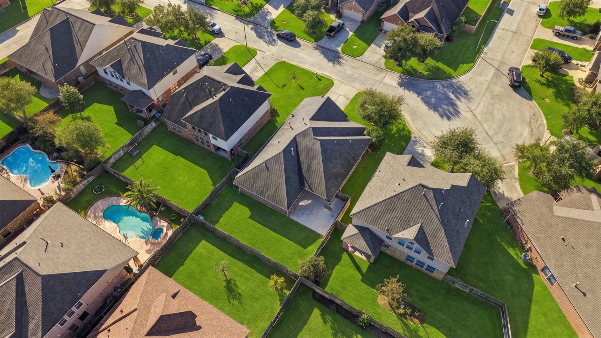 6414 Pinyon Trail Drive, Spring, TX 77389 Charming suburban neighborhood with beautifully maintained homes and lush green lawns, featuring inviting backyard pools perfect for relaxation and entertainment.