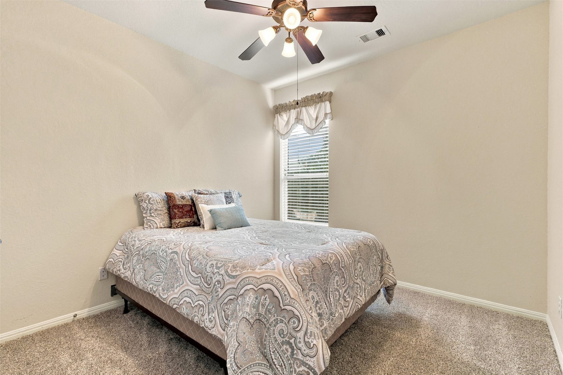 6414 Pinyon Trail Drive, Spring, TX 77389 Cozy bedroom featuring neutral tones, plush carpeting, and a ceiling fan, offering comfort and style.