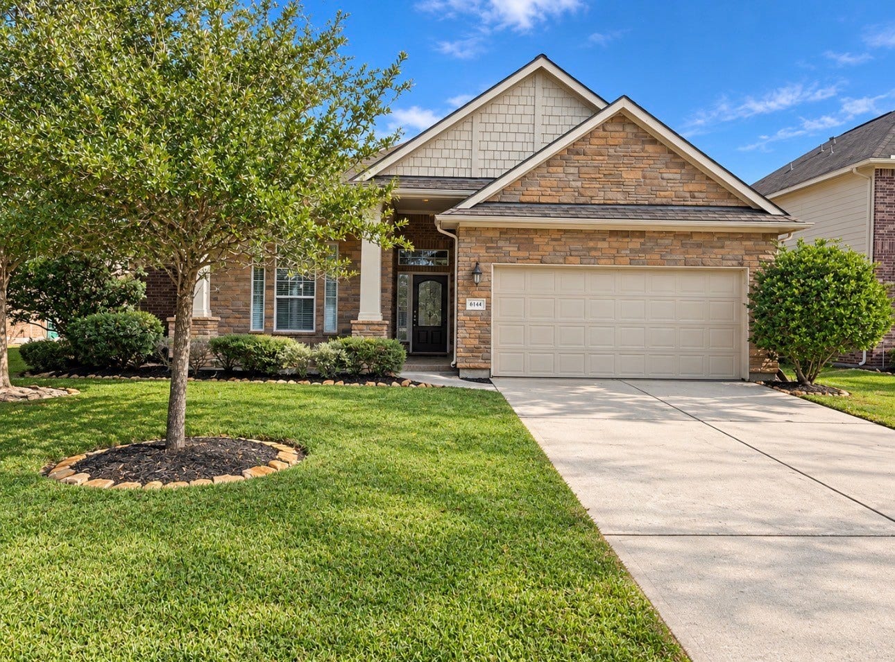 6414 Pinyon Trail Drive, Spring, TX 77389 The perfect single-story home with a stone facade and inviting front porch. Features a well-maintained lawn, mature tree, and a spacious two-car garage.