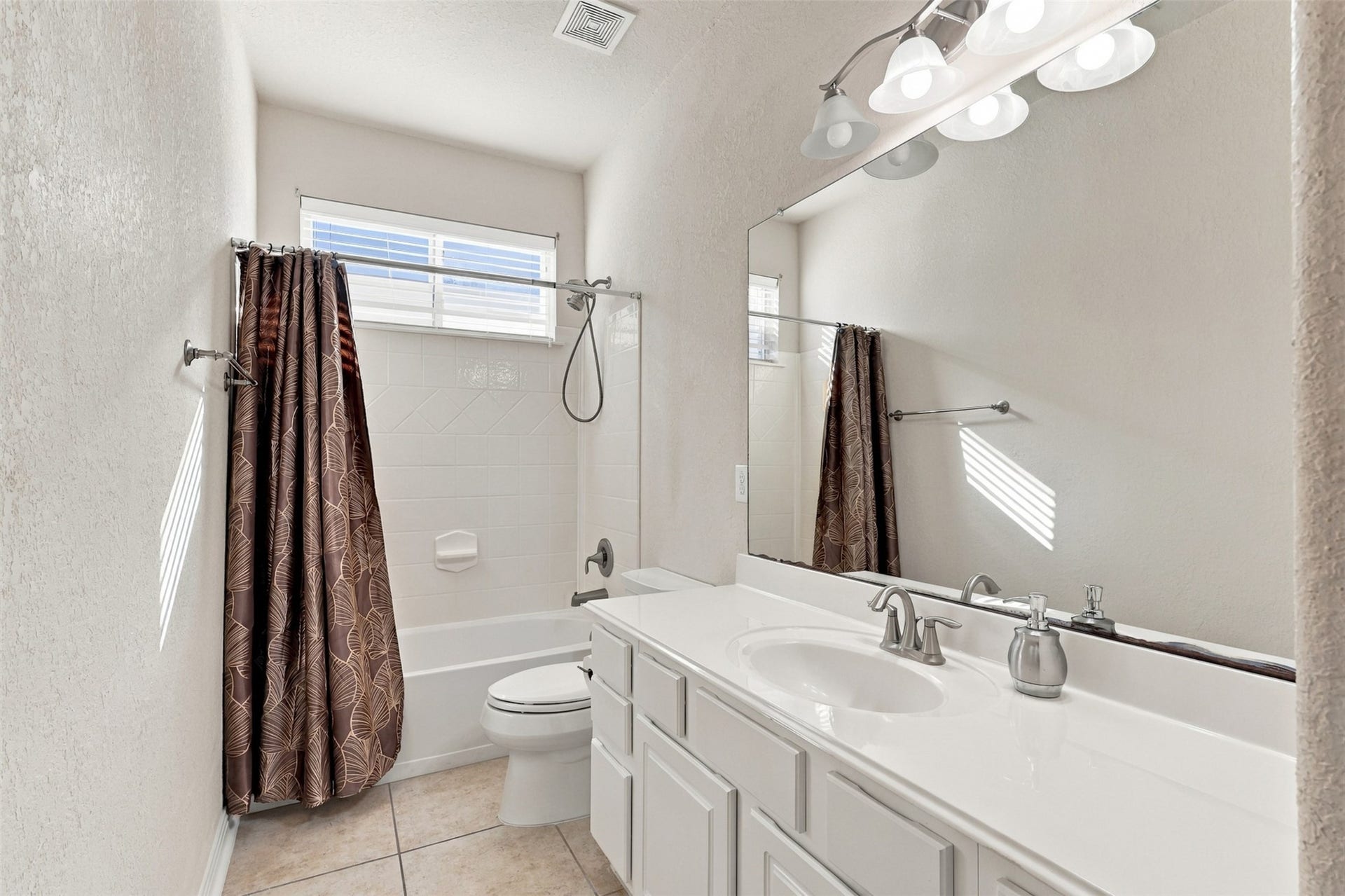 6414 Pinyon Trail Drive, Spring, TX 77389 Bright and inviting bathroom featuring a spacious vanity, elegant fixtures, and a shower-tub combo with a stylish curtain.