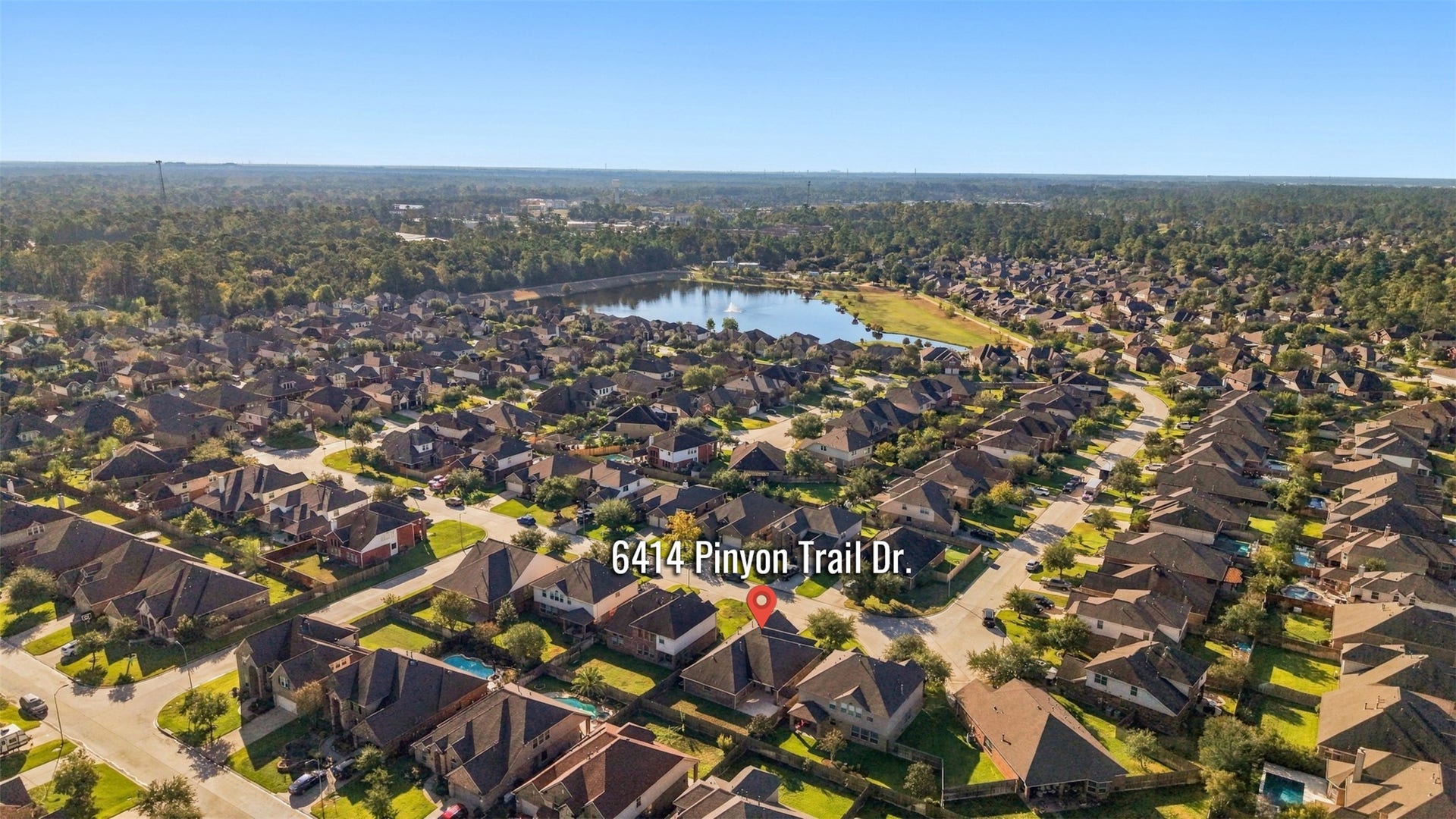 6414 Pinyon Trail Drive, Spring, TX 77389 The neighborhood with a serene lake view, nestled among lush greenery and well-maintained homes, offering a peaceful suburban lifestyle.