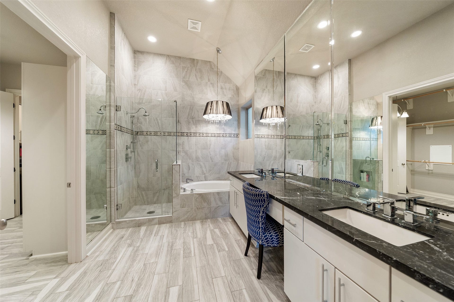 Primary bathroom with shower and tub. Dual sinks, vanity area and beautiful lighting.