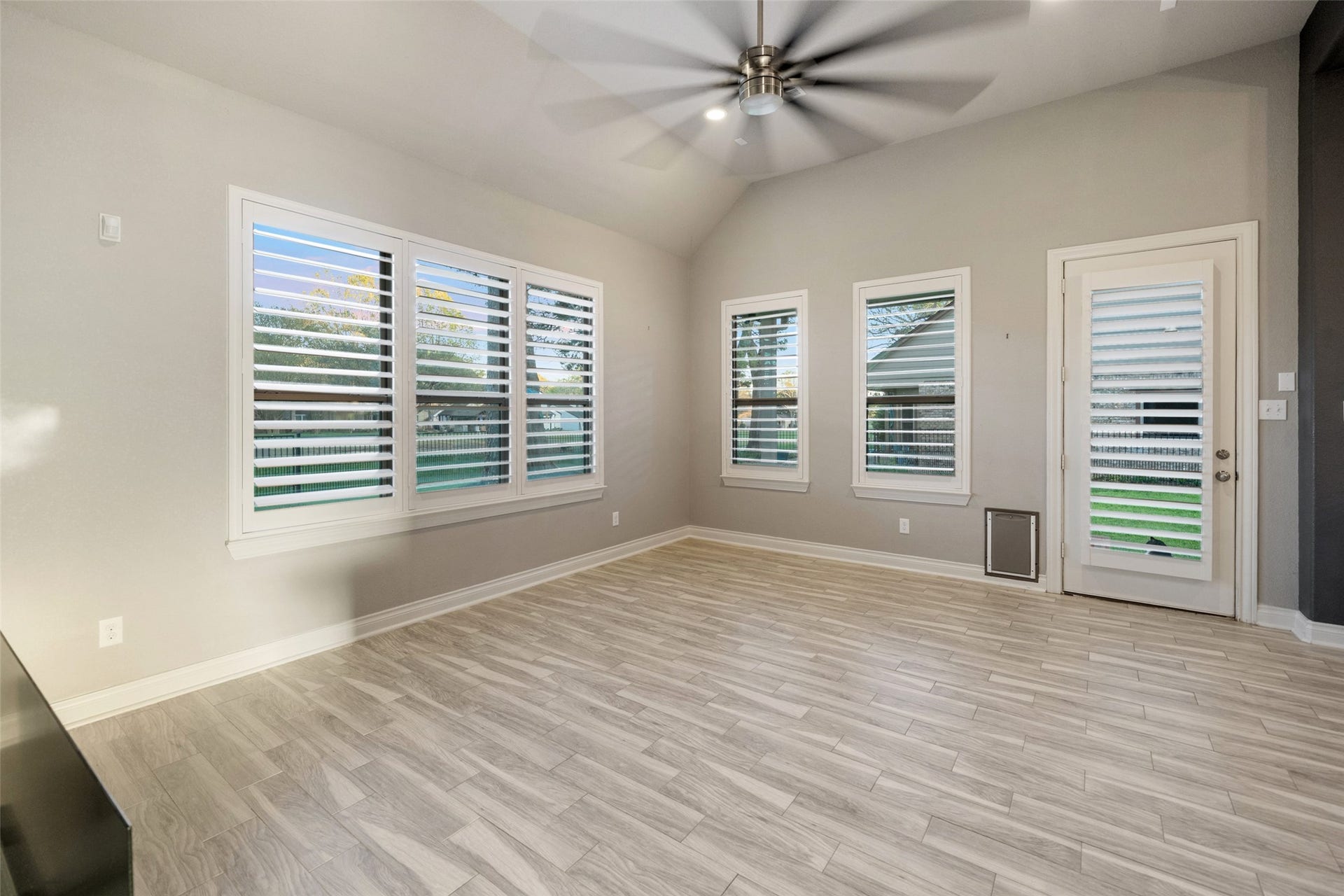 Living area with golf course views and patio access. Enjoy the Shutters throughout the home.