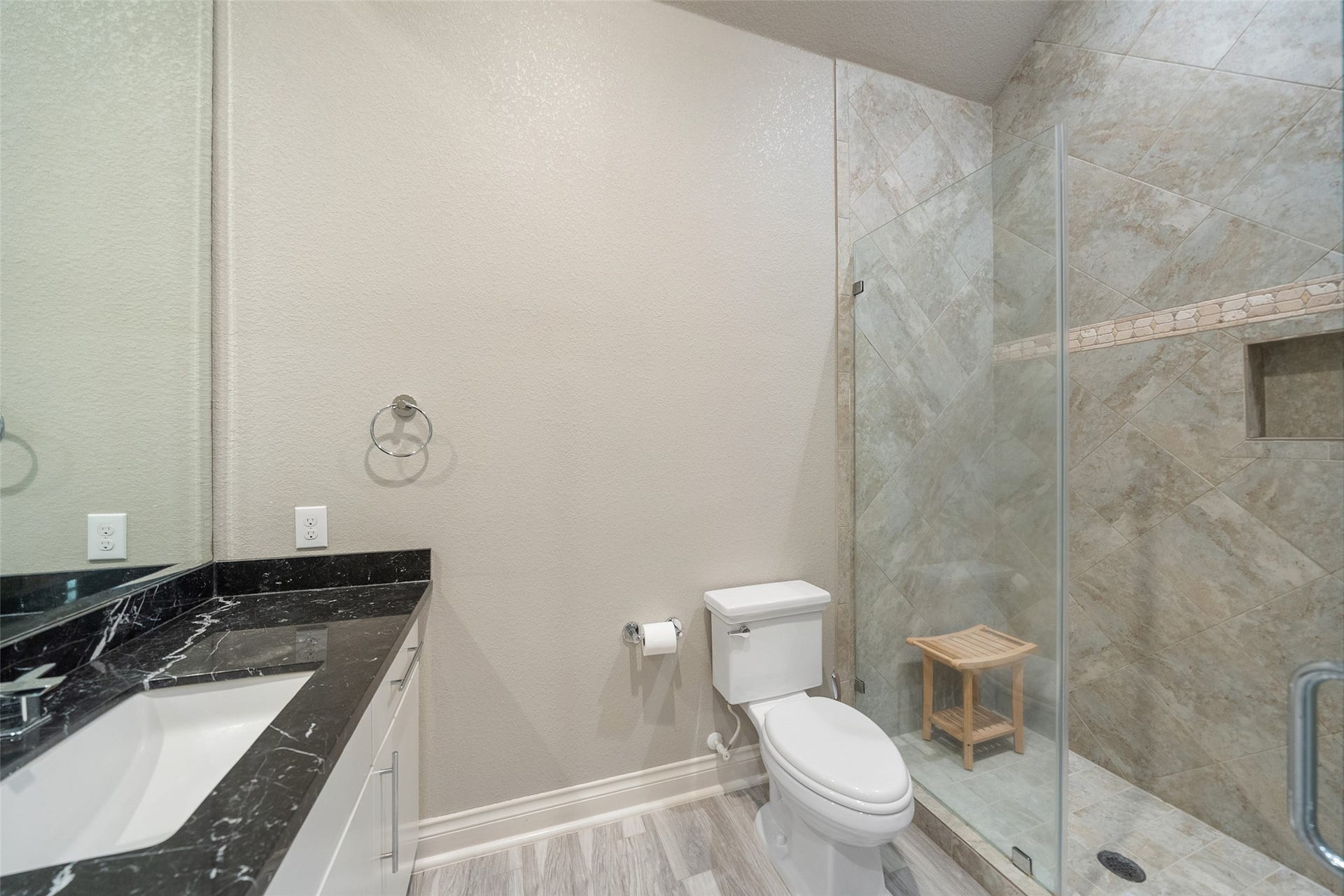 The en-suite bathroom has a walk in shower and marble counters.