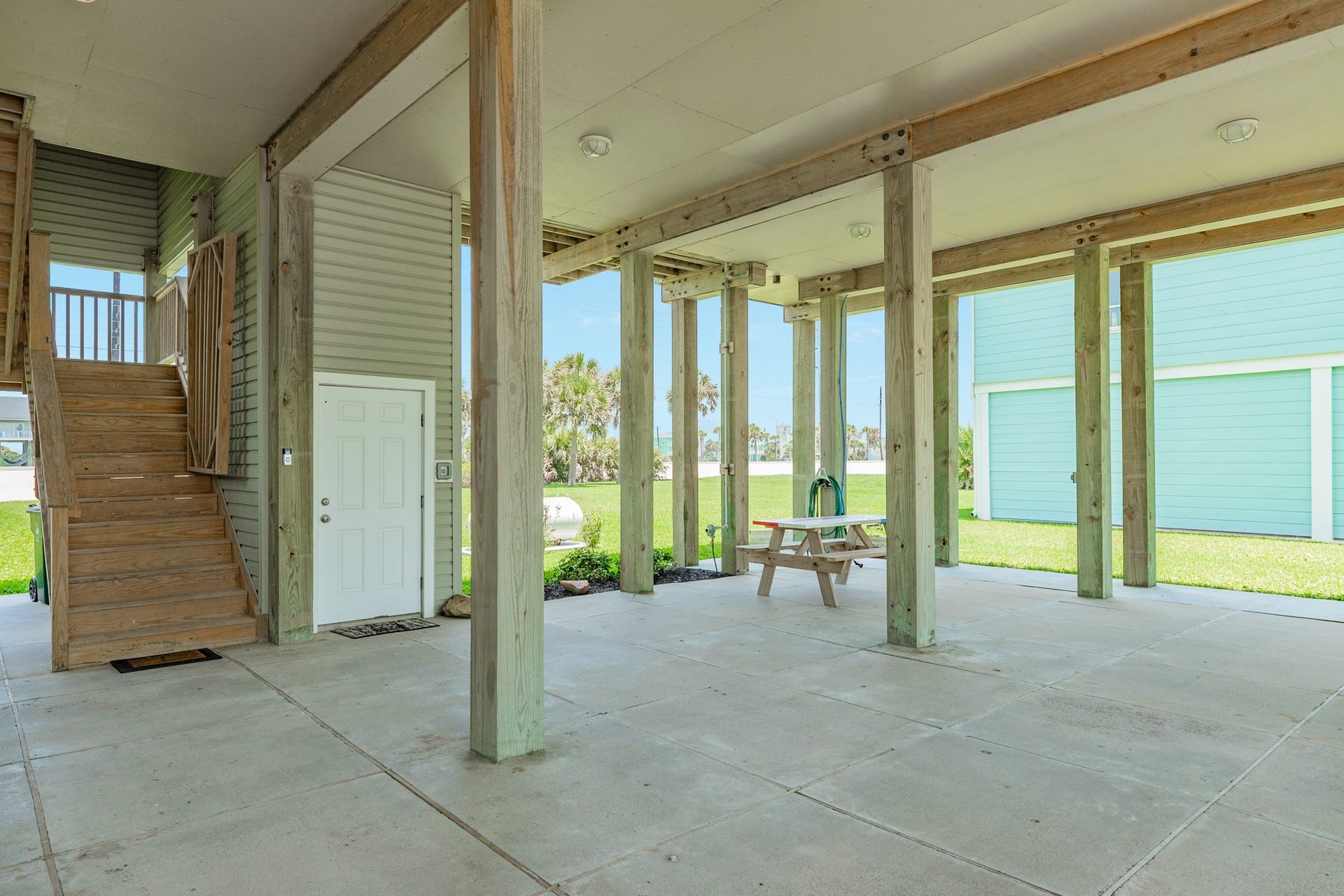 18502 E De Vaca, Galveston, TX 77554 Spacious ground floor patio area. In view is the stair case leading up into the home and the elevator entrance.