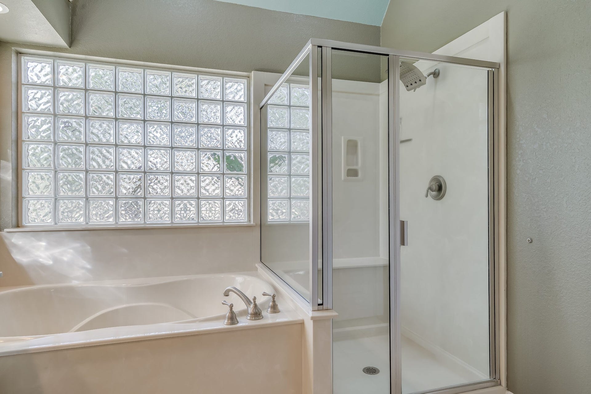 2500 Centerline Road, Conroe, TX 77384 Experience ultimate relaxation with a luxurious soaking tub and sleek separate shower, bathed in natural light through elegant glass block windows