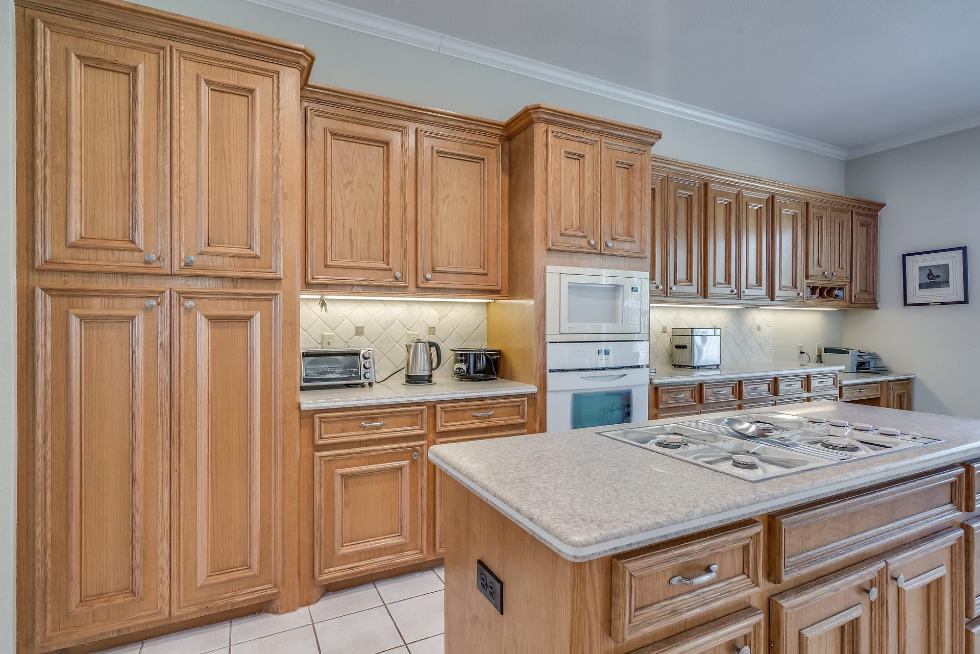 2500 Centerline Road, Conroe, TX 77384 Discover a beautifully designed kitchen featuring built-in cabinetry, sleek Silestone countertops, elegant tile flooring, and a convenient desk area for seamless functionality