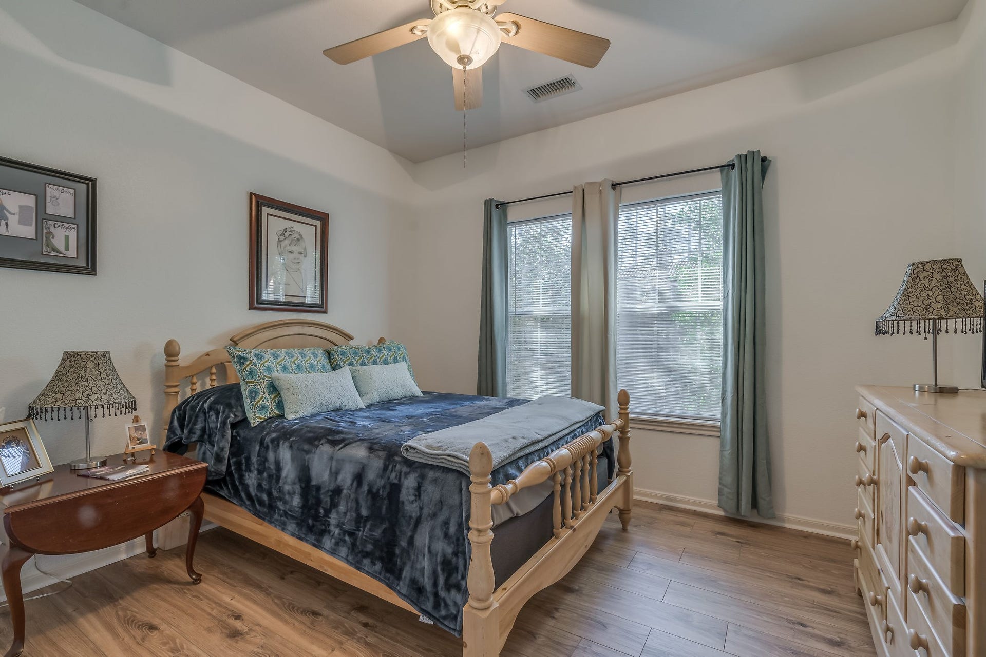 2500 Centerline Road, Conroe, TX 77384 Experience comfort and style in Bedroom 3, featuring a ceiling fan, elegant tray ceiling, and laminate wood floors
