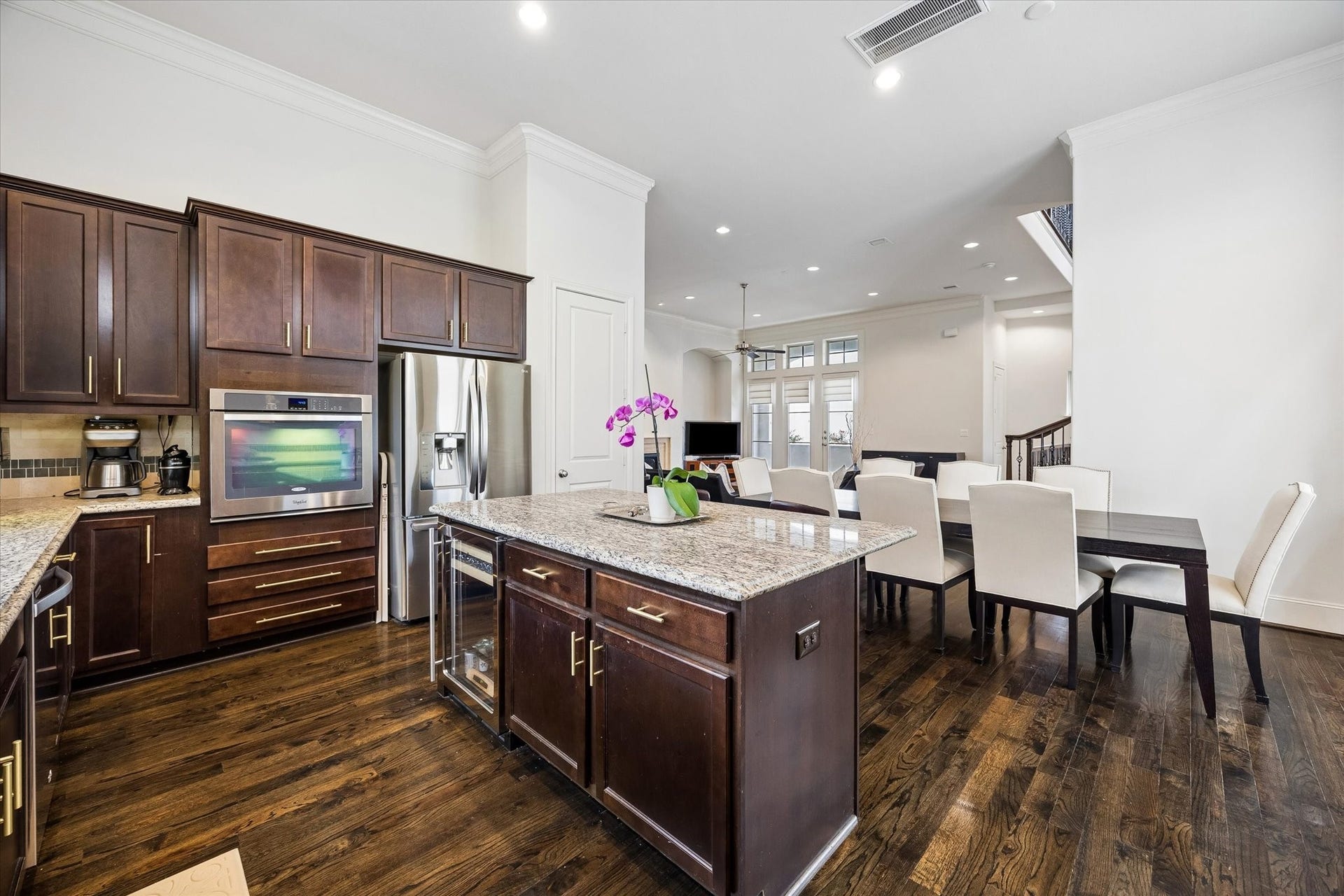 2725 Cohn Garden, Houston, TX 77007 Open sightlines connect the kitchen, dining area, and living room, creating an easy flow for everyday living and entertaining. The oversized island anchors the kitchen with added storage, counter space, and a built in beverage refrigerator.