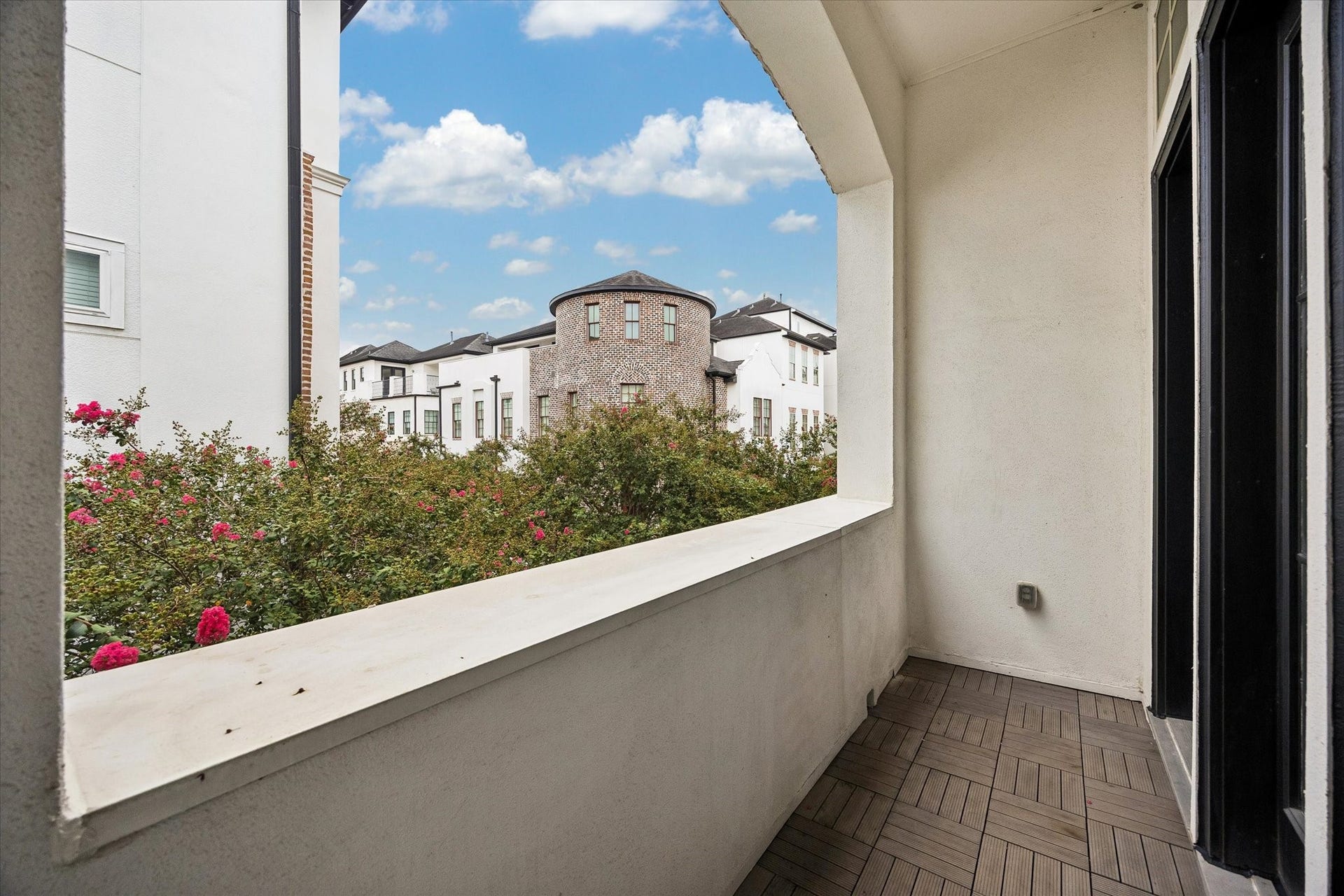 2725 Cohn Garden, Houston, TX 77007 A private covered balcony creates a quiet outdoor escape with views across the landscaped community and surrounding architecture, offering a peaceful spot to enjoy fresh air without leaving home.