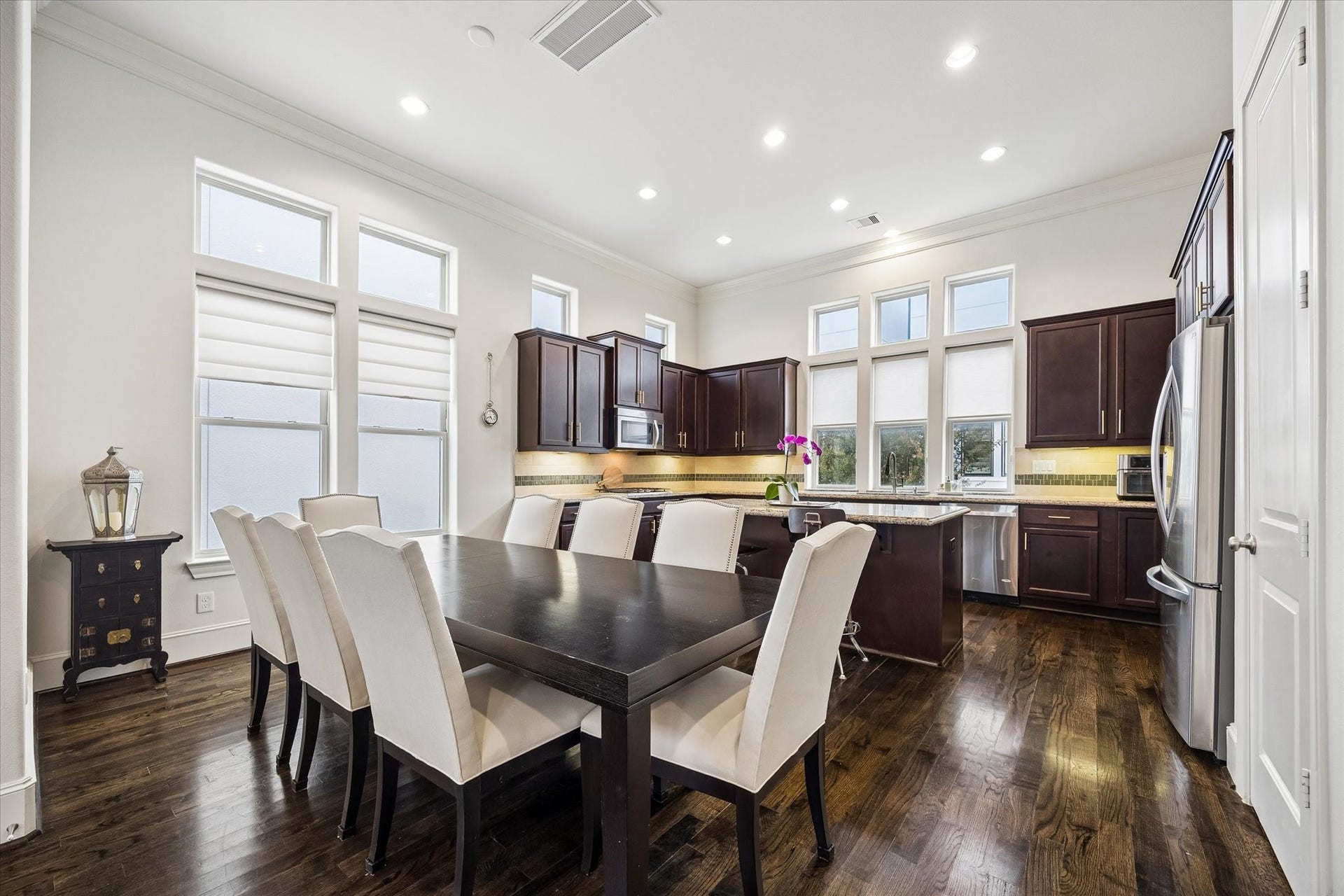 2725 Cohn Garden, Houston, TX 77007 Abundant windows and recessed lighting keep the kitchen and dining area bright, while rich cabinetry and hardwood floors add warmth throughout. An oversized island creates a natural gathering point with plenty of room for meal prep and casual seating.